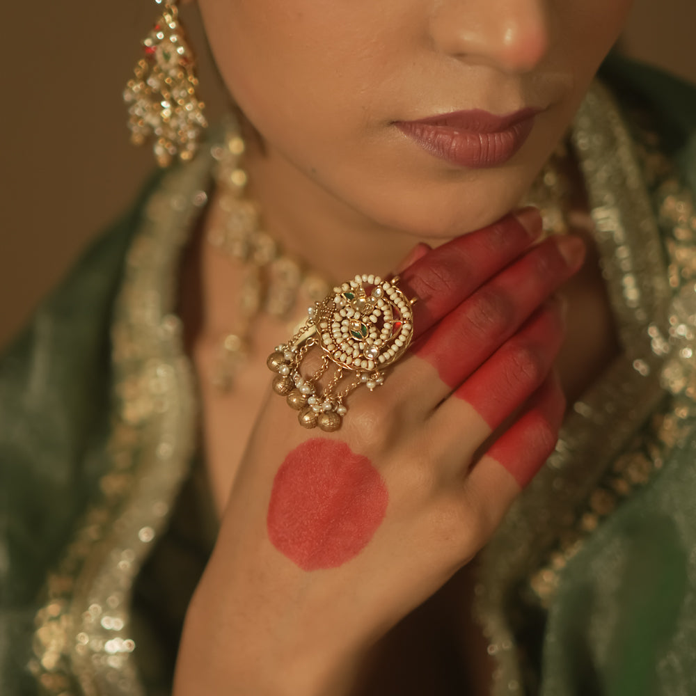 Gold ring with a swirl design, pearls, and small gems.