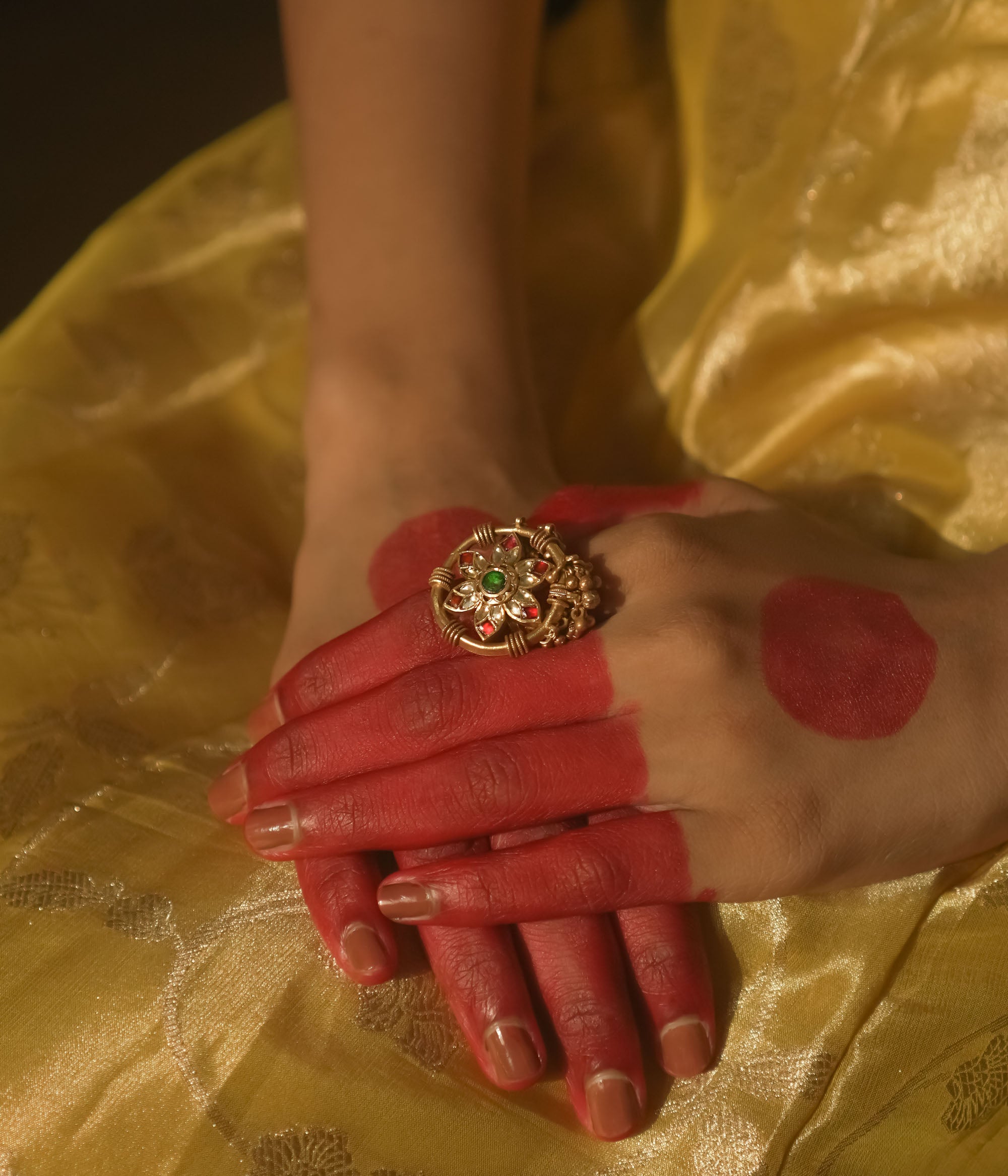 Gold-plated silver ring with a mandala design and green, red, and clear Kundan stones.