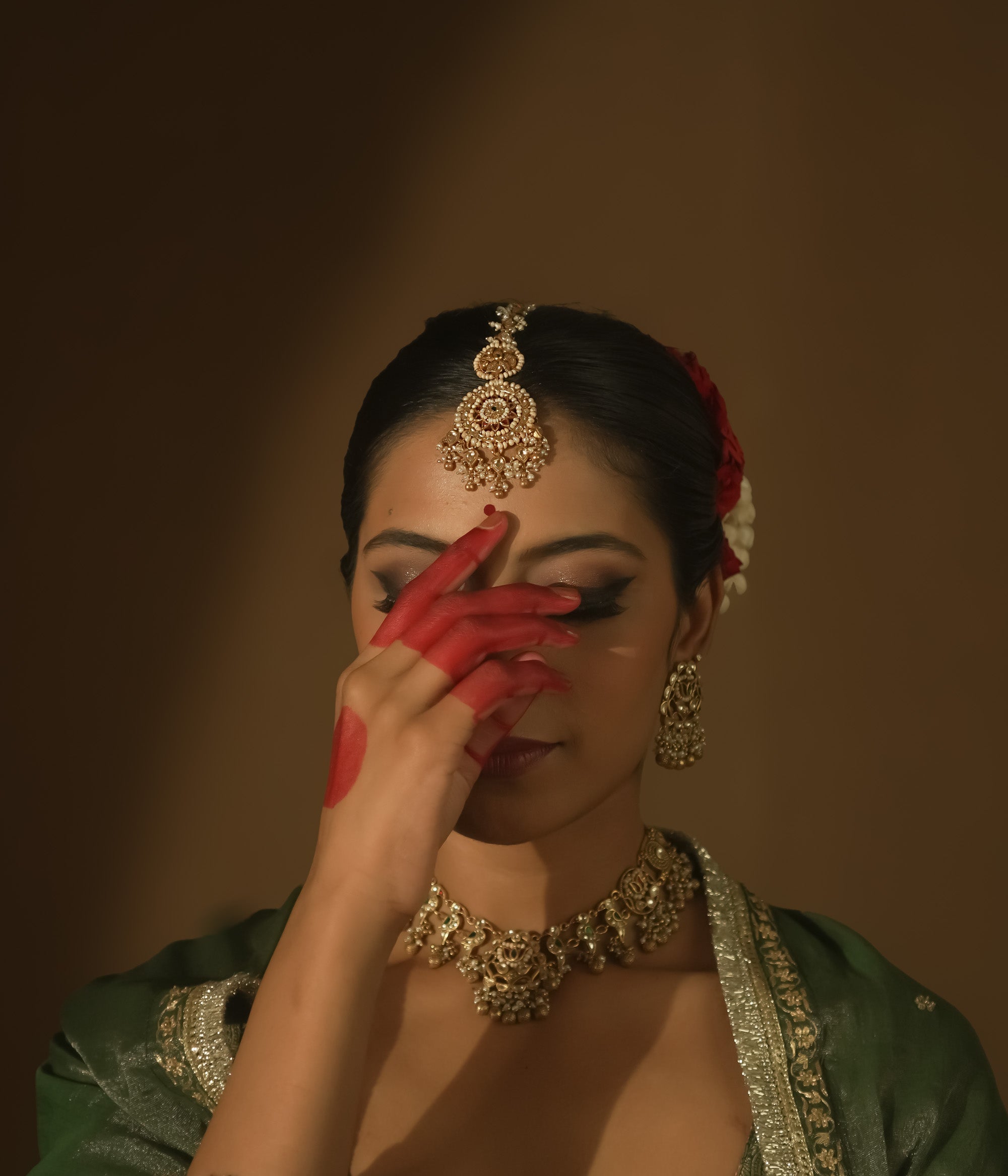 Gold maangtika with filigree, Kundan stones, and a large medallion with pearl drops.