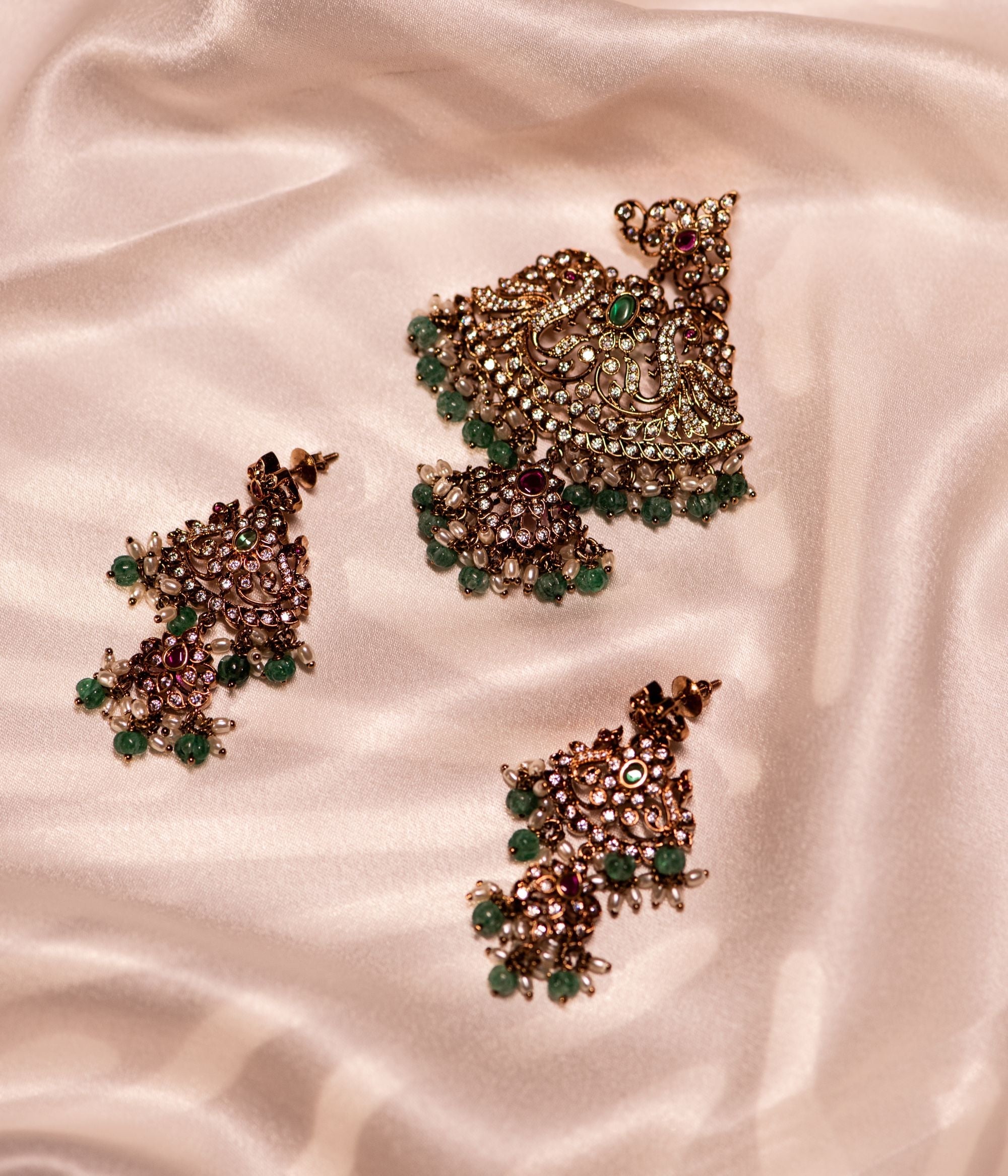 Gold-plated silver Pendant  adorned with Moissanite Polki stones, CZ stones, green cut stones, and red spinel stones, elegantly complemented by green beads and white pearls, creating a timeless and sophisticated look.