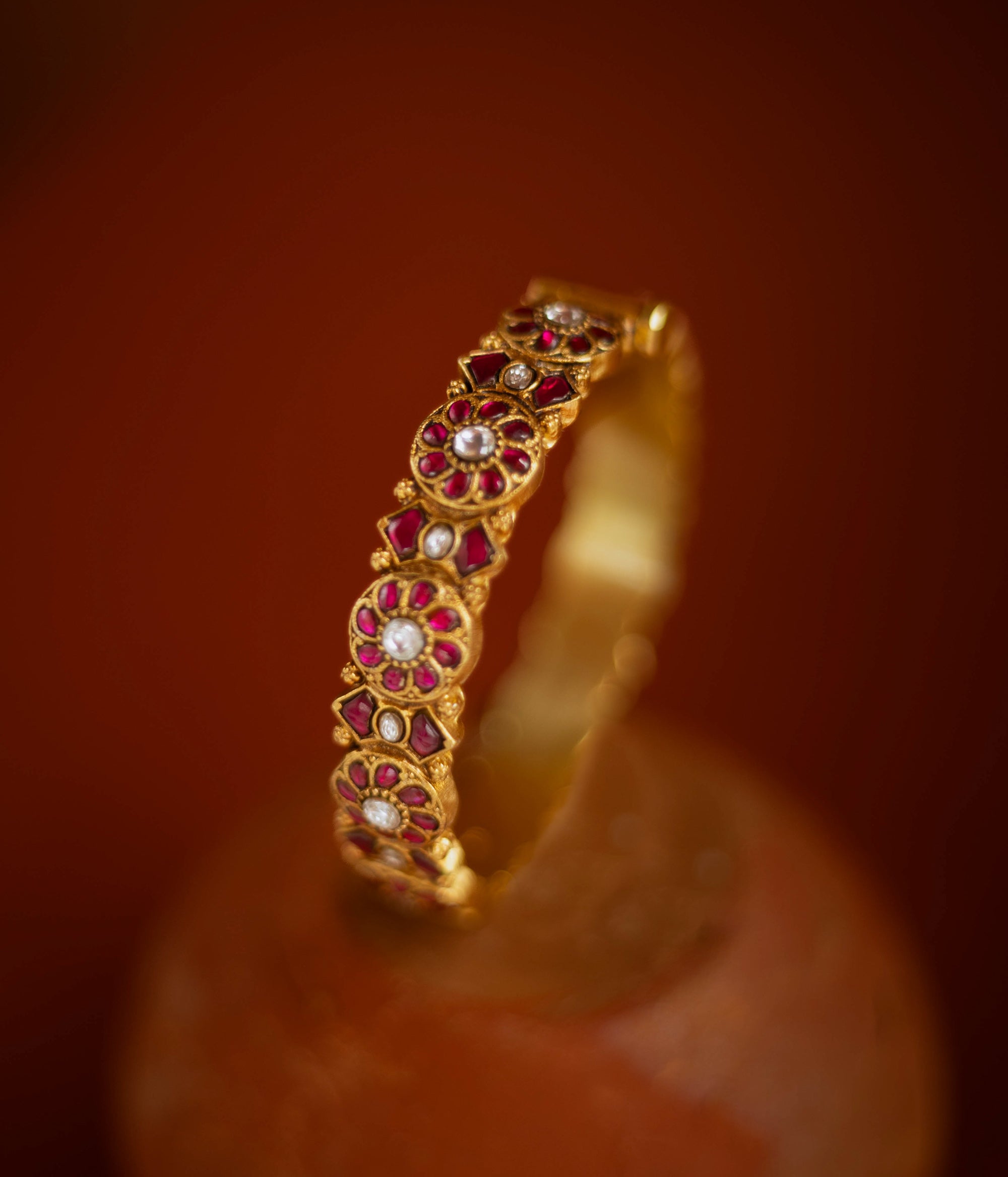 Gold bangle with red and white Kundan stones in floral pattern from Kundan collection.