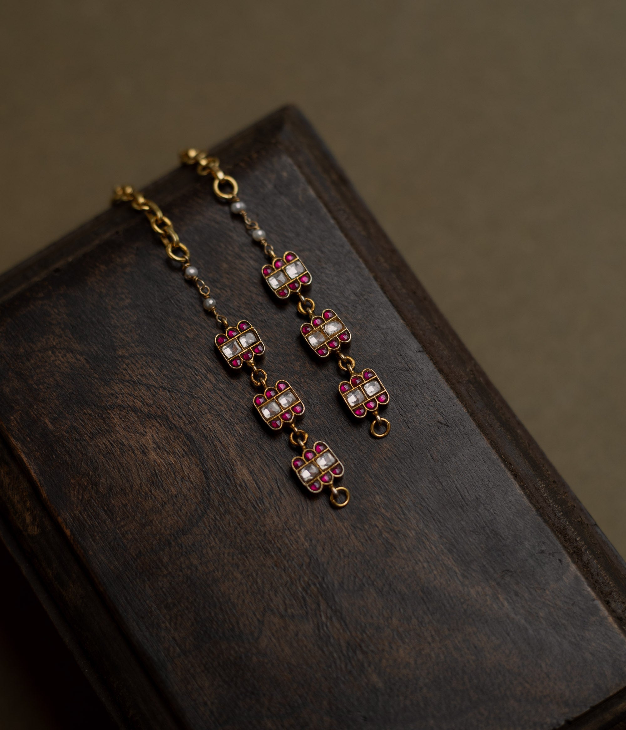 Kundan Collection ear chain with red kundan stones and white kundan highlights in flame-inspired motif.