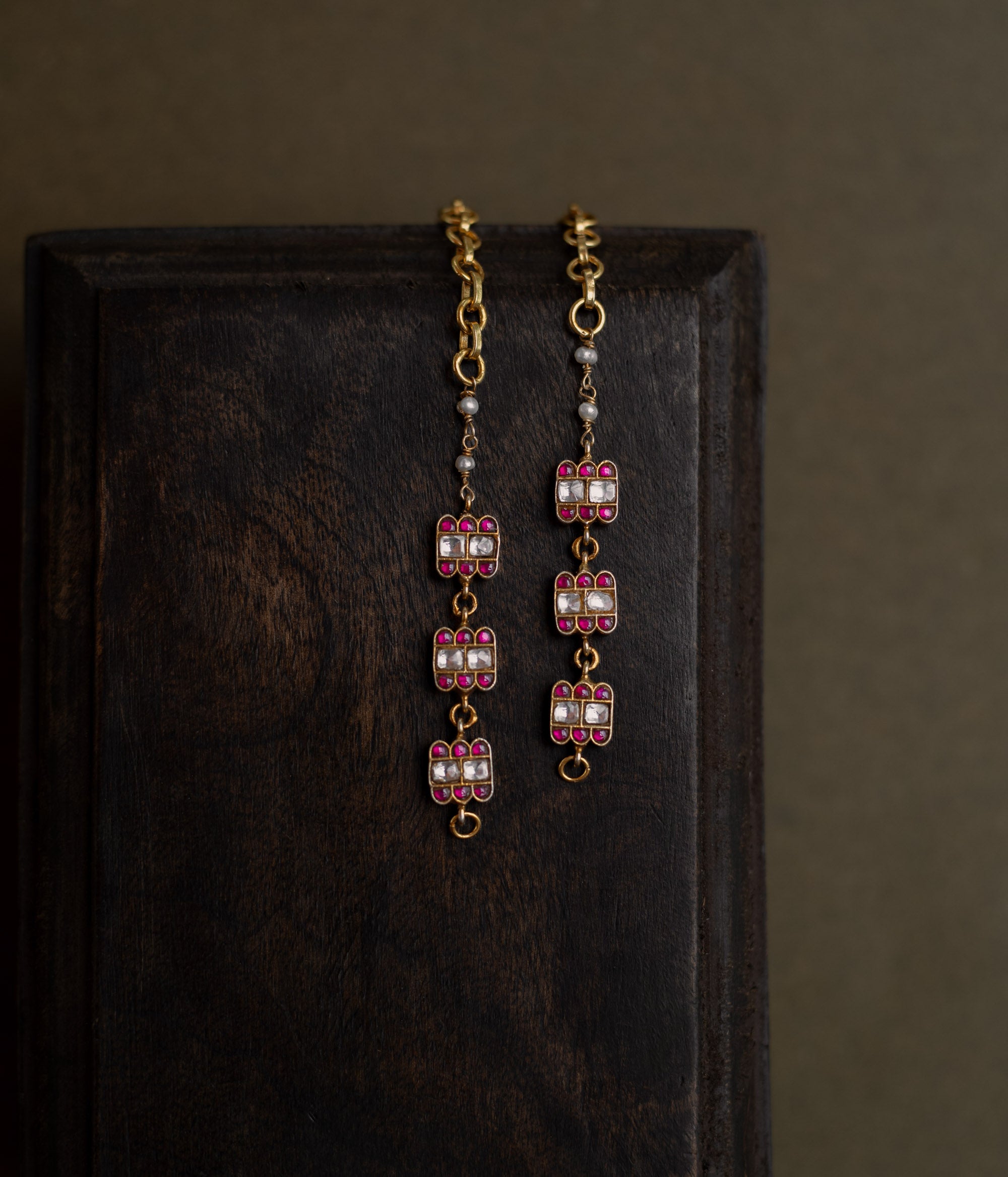 Kundan Collection ear chain with red kundan stones and white kundan highlights in flame-inspired motif.