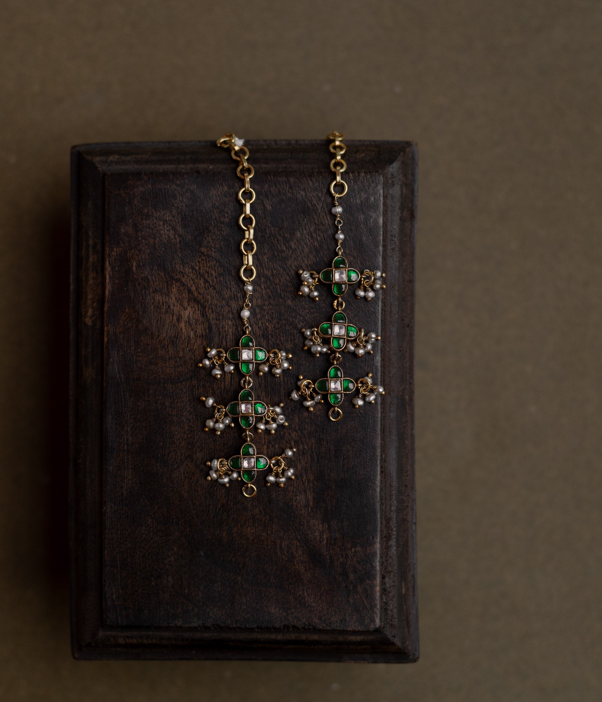 Kundan Collection ear chain with red kundan stones and white kundan highlights in flame-inspired motif.