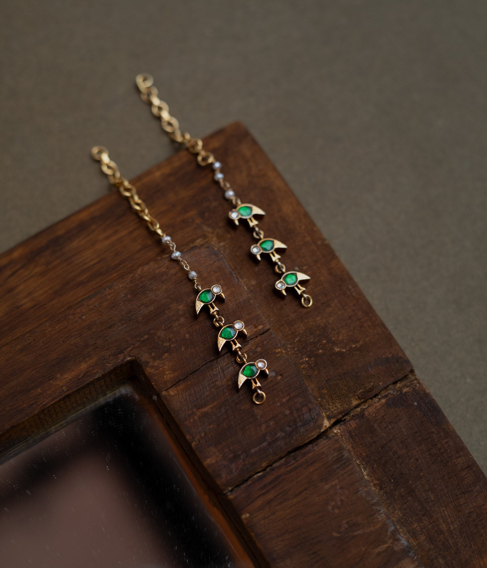 Kundan Collection ear chain with green kundan leaf motifs and white kundan accents in vine design.