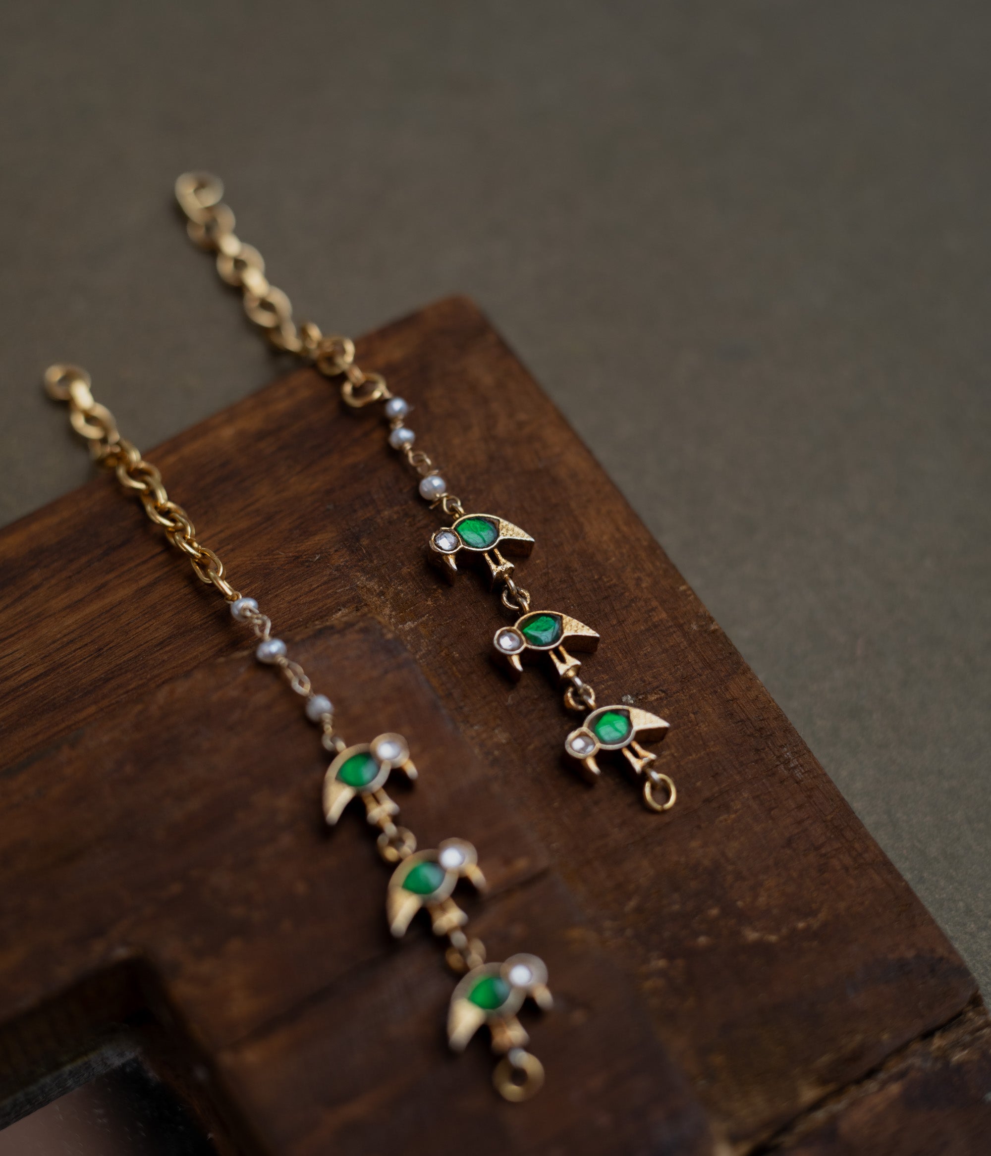 Kundan Collection ear chain with green kundan leaf motifs and white kundan accents in vine design.