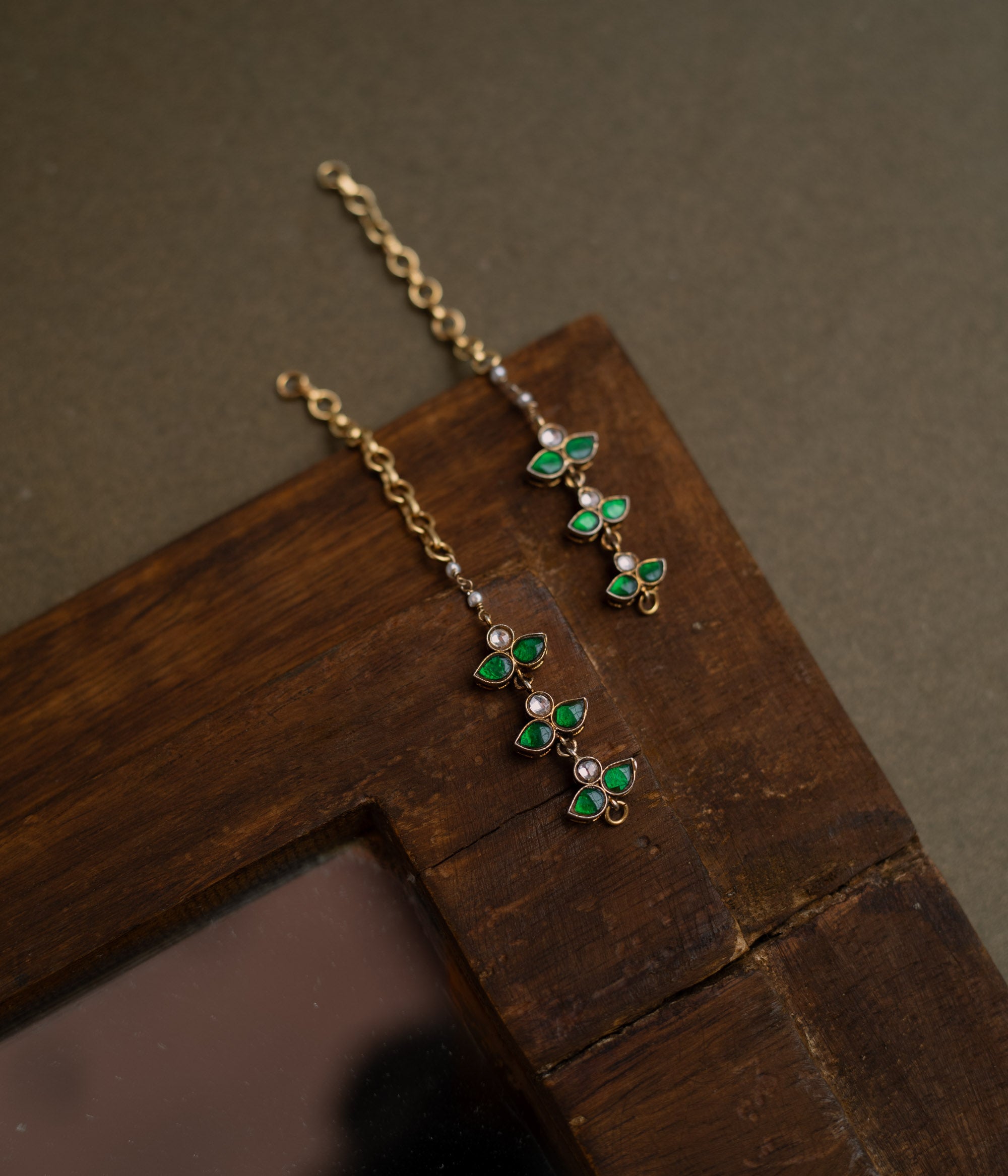 Kundan Collection ear chain with white and green kundan stones in a delicate floral design.