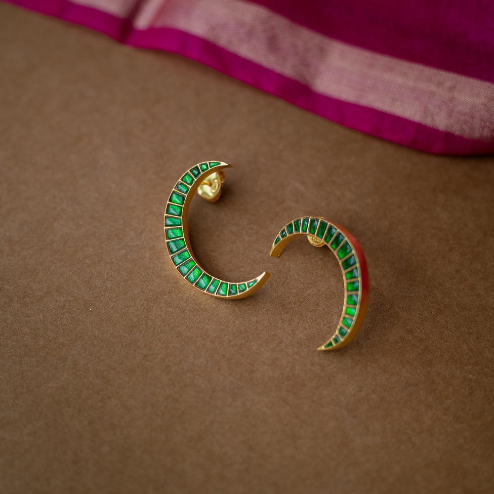 A pair of green Kundan drop earrings with intricate patterns.