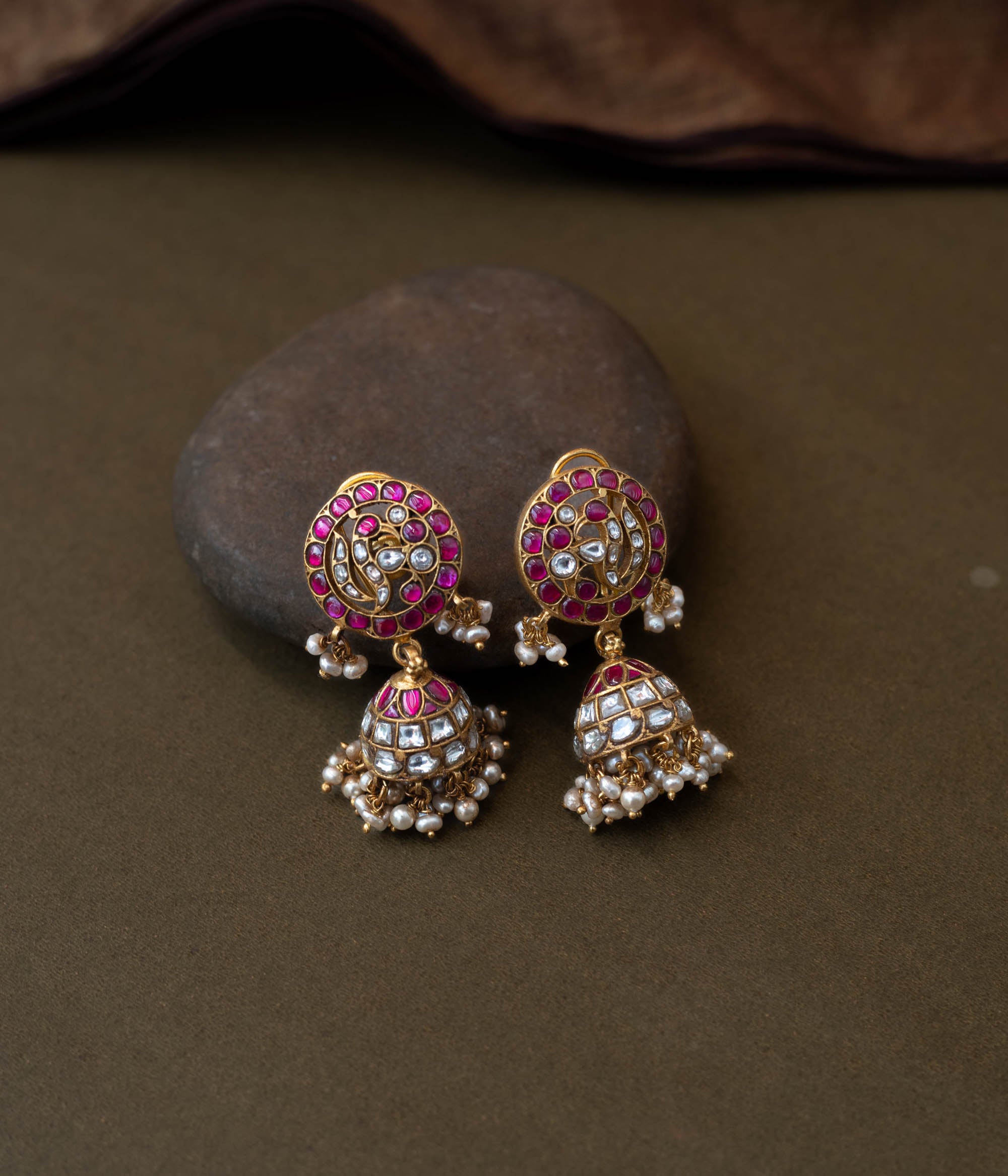 Vibrant Rang Mahal Jadau Earrings blending classic meenakari artistry with Kundan sparkle. Circular studs with ruby pink and mirror-polished white stones flow into dome-shaped jhumkas finished with delicate pearl hangings, perfect for weddings and festive occasions.