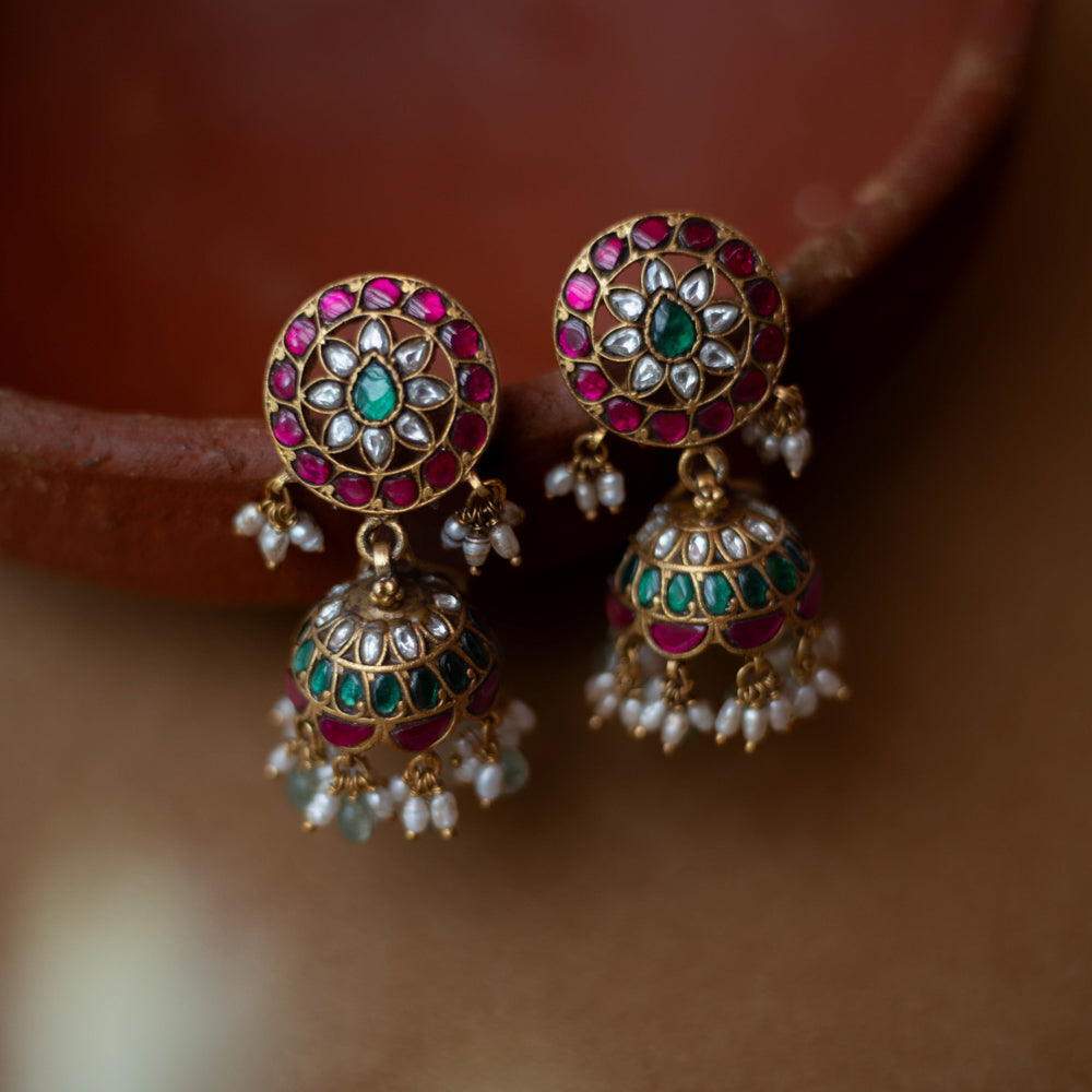 Round floral Kundan earrings with dome-shaped jhumkas, pearls, and green bead hangings.