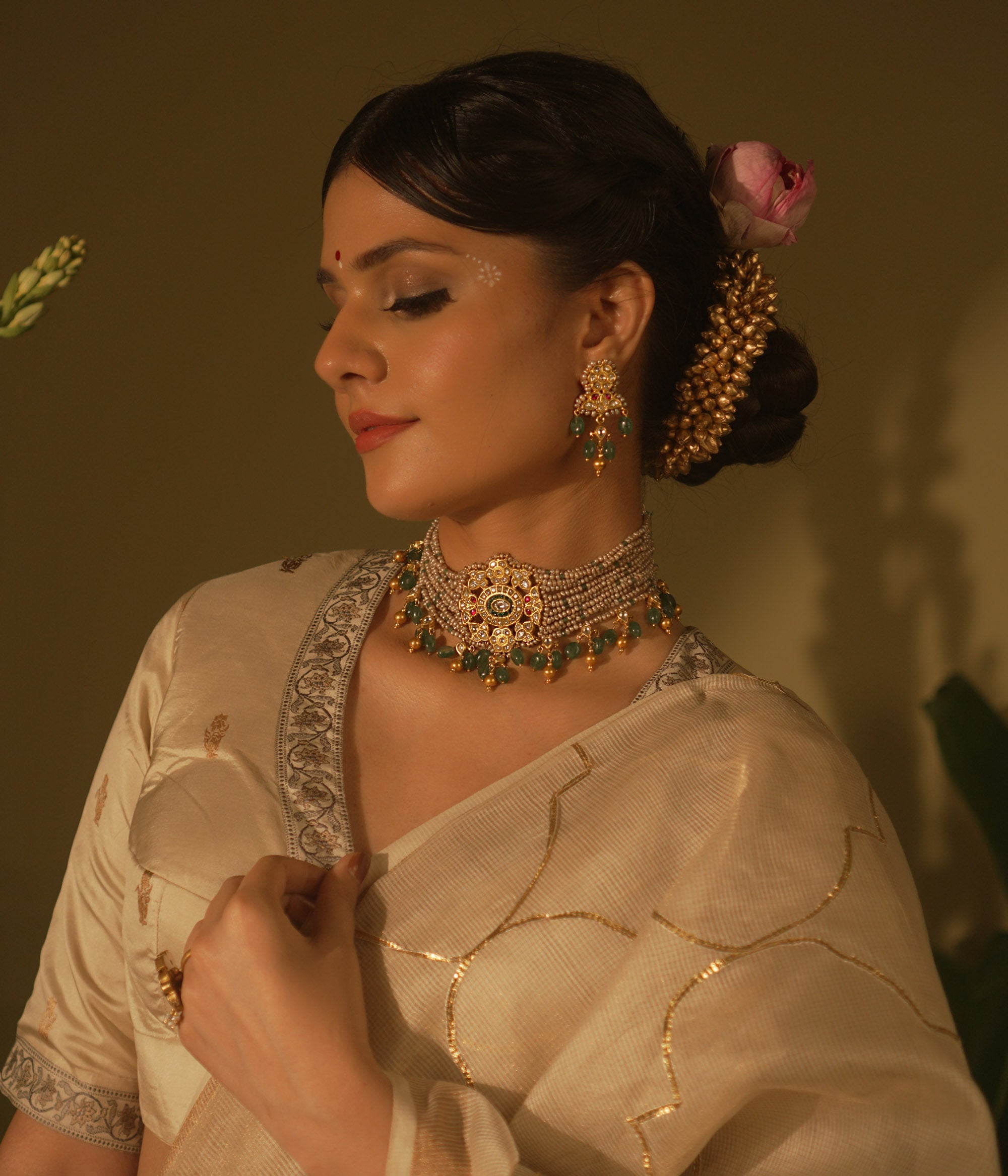 Gold-toned Kundan earrings with red and white stones, green bead drops, and pearl accents—traditional and regal design.