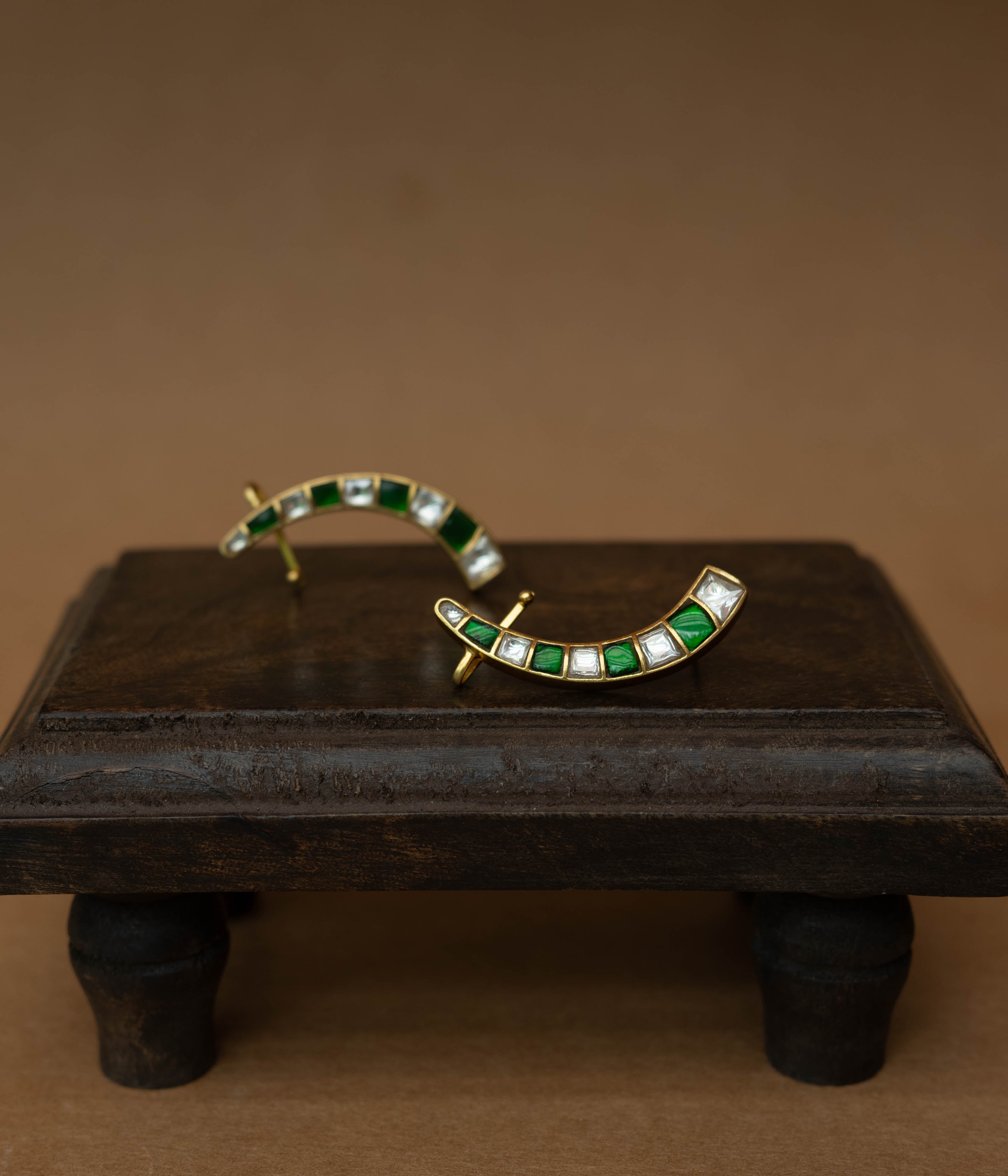 Curved ear crawlers with alternating green and white square stones.
