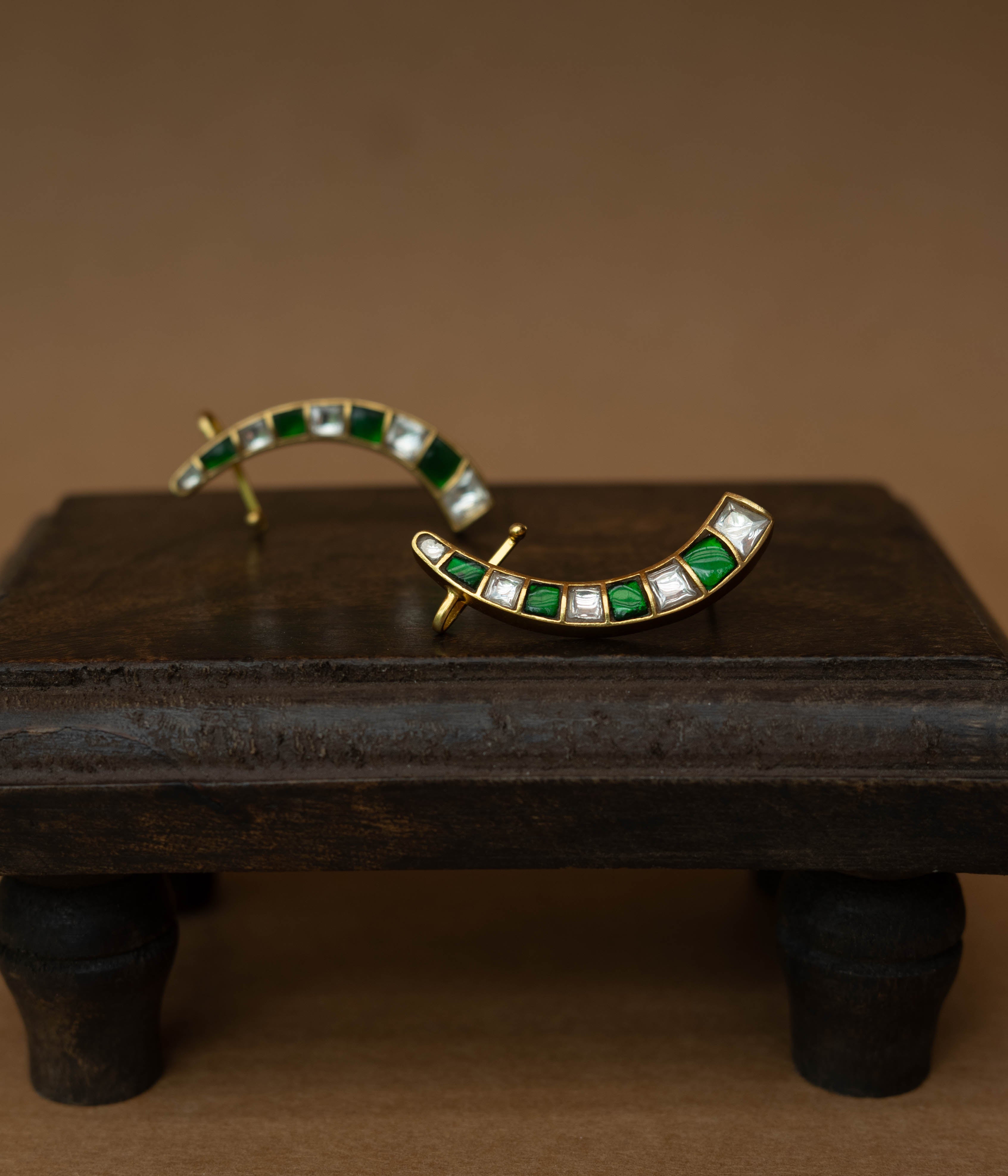 Curved ear crawlers with alternating green and white square stones.