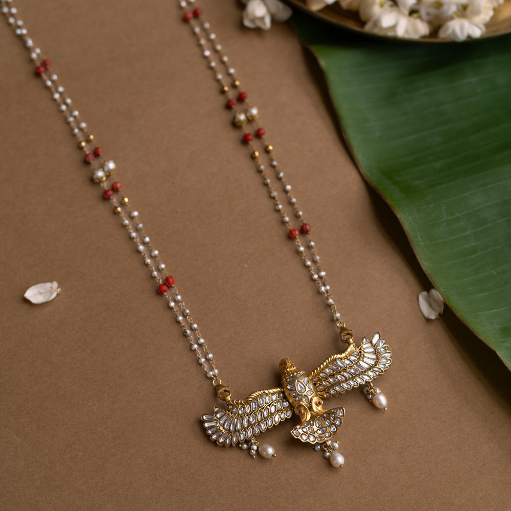 A Kundan necklace with floral motifs and three rows of pearl tassels.