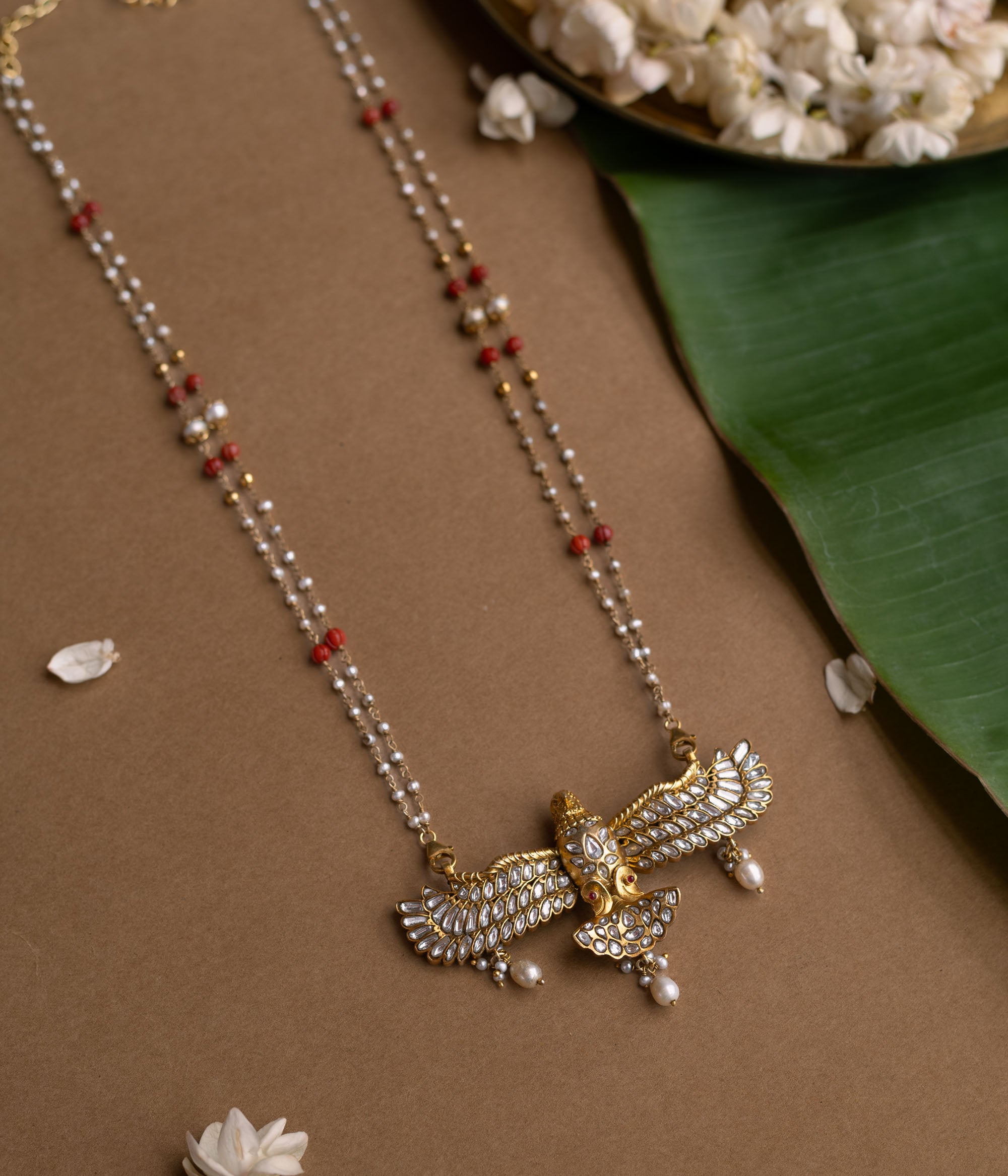 A Kundan necklace with floral motifs and three rows of pearl tassels.