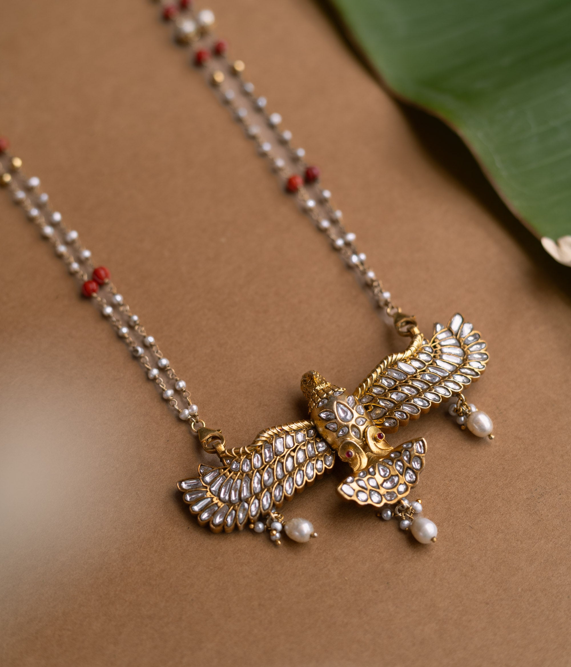 A Kundan necklace with floral motifs and three rows of pearl tassels.