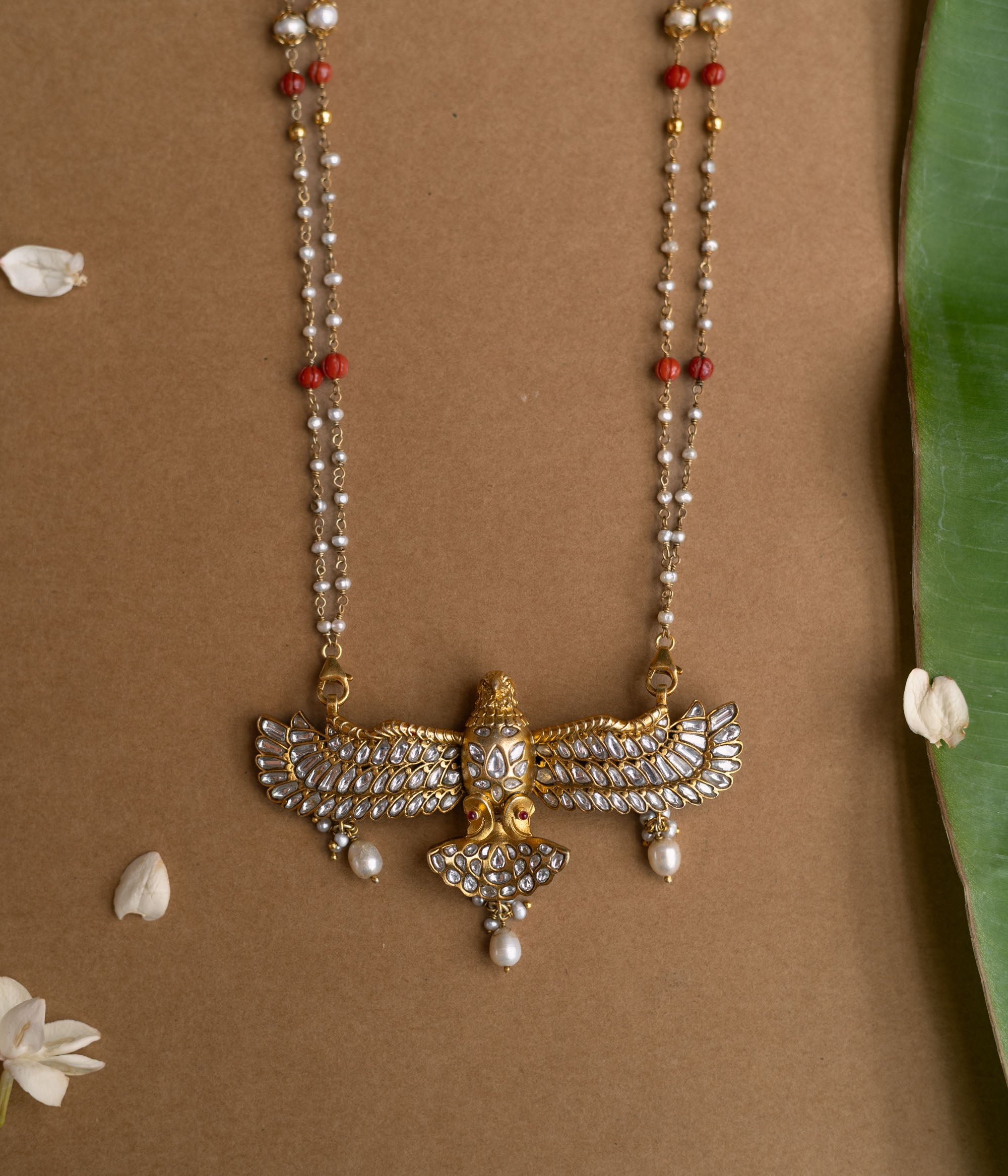 A Kundan necklace with floral motifs and three rows of pearl tassels.