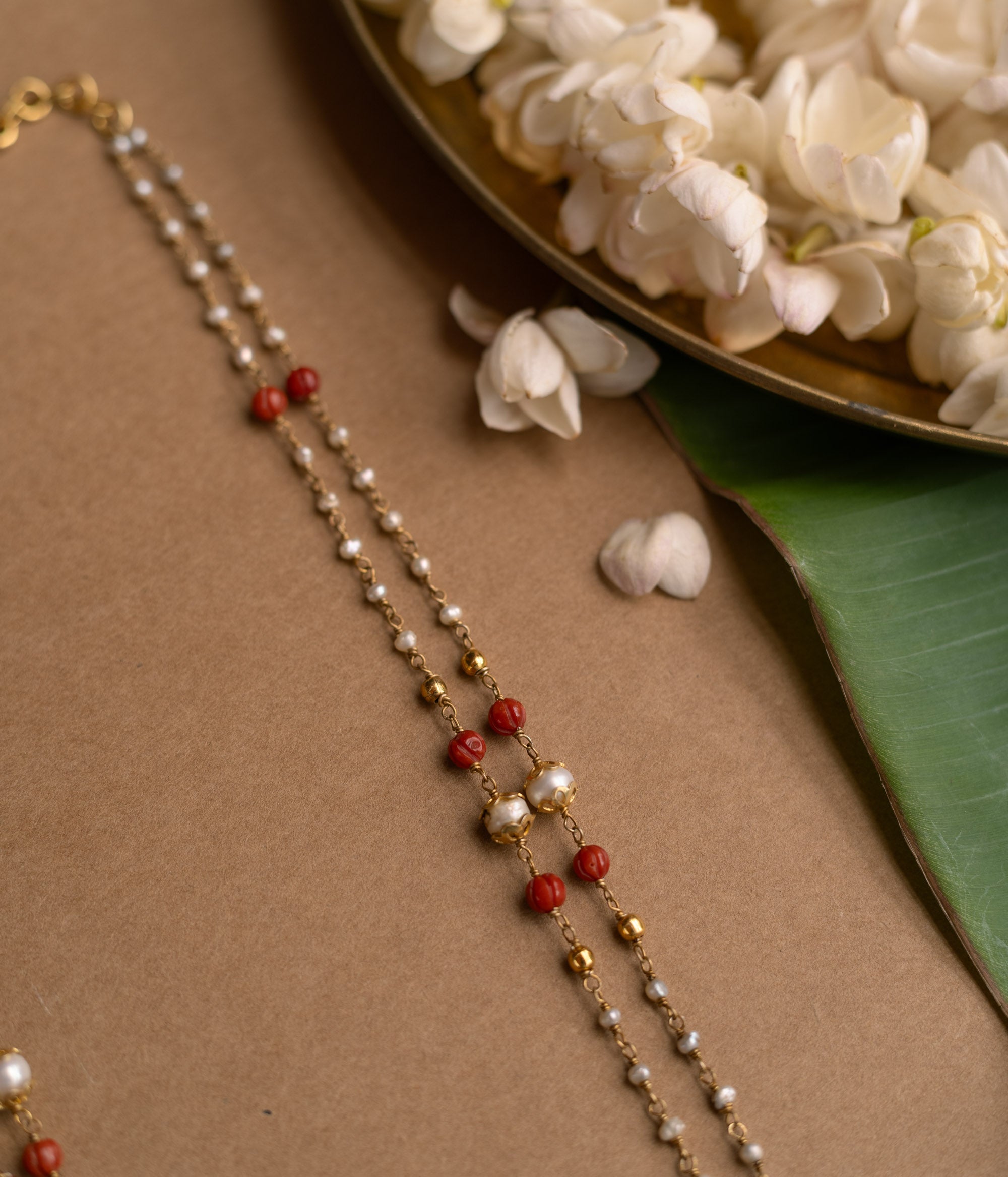 A Kundan necklace with floral motifs and three rows of pearl tassels.
