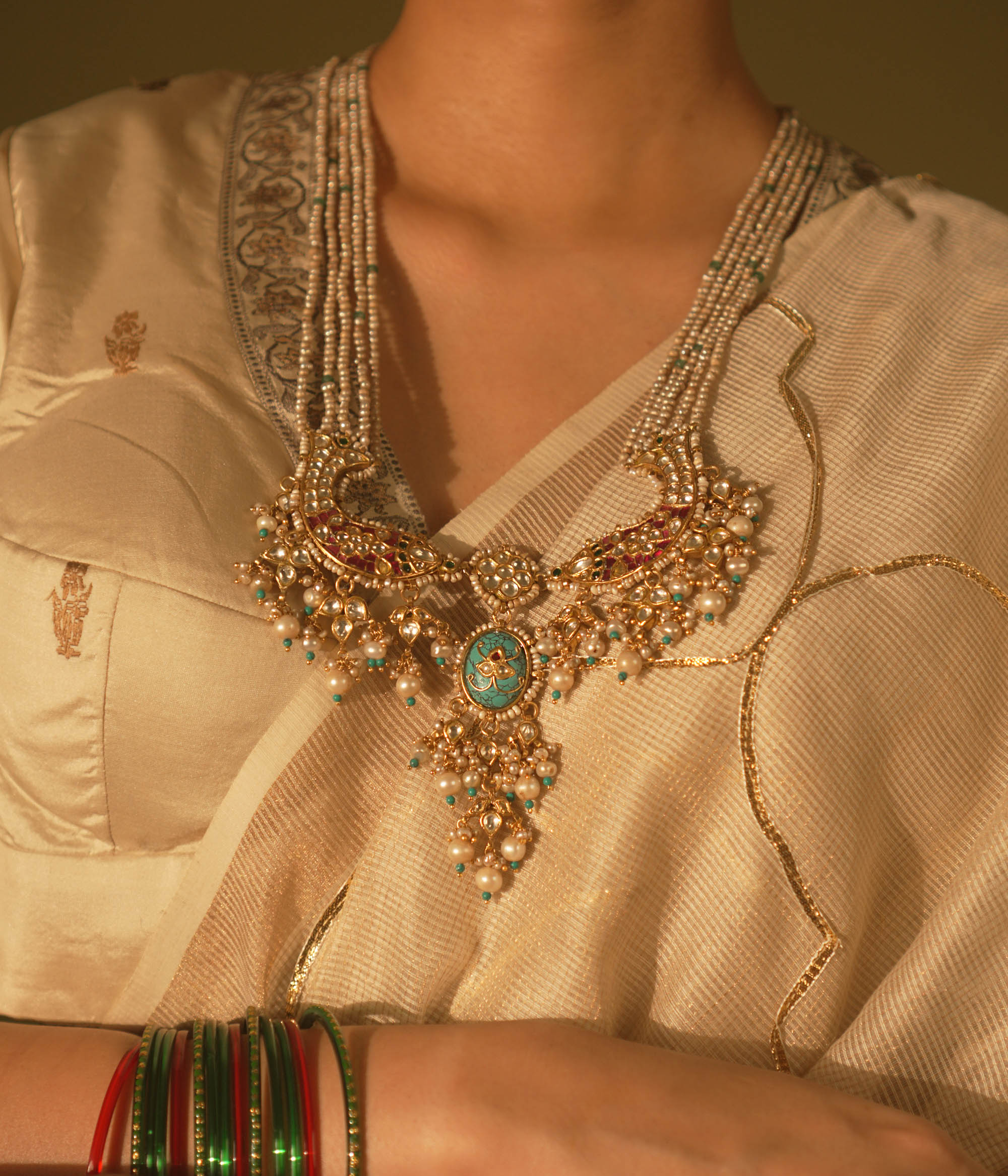  Gold-veiled silver necklace with abstract fish motifs, pearls, and Kundan stones—blending heritage, ocean lore, and artistry.