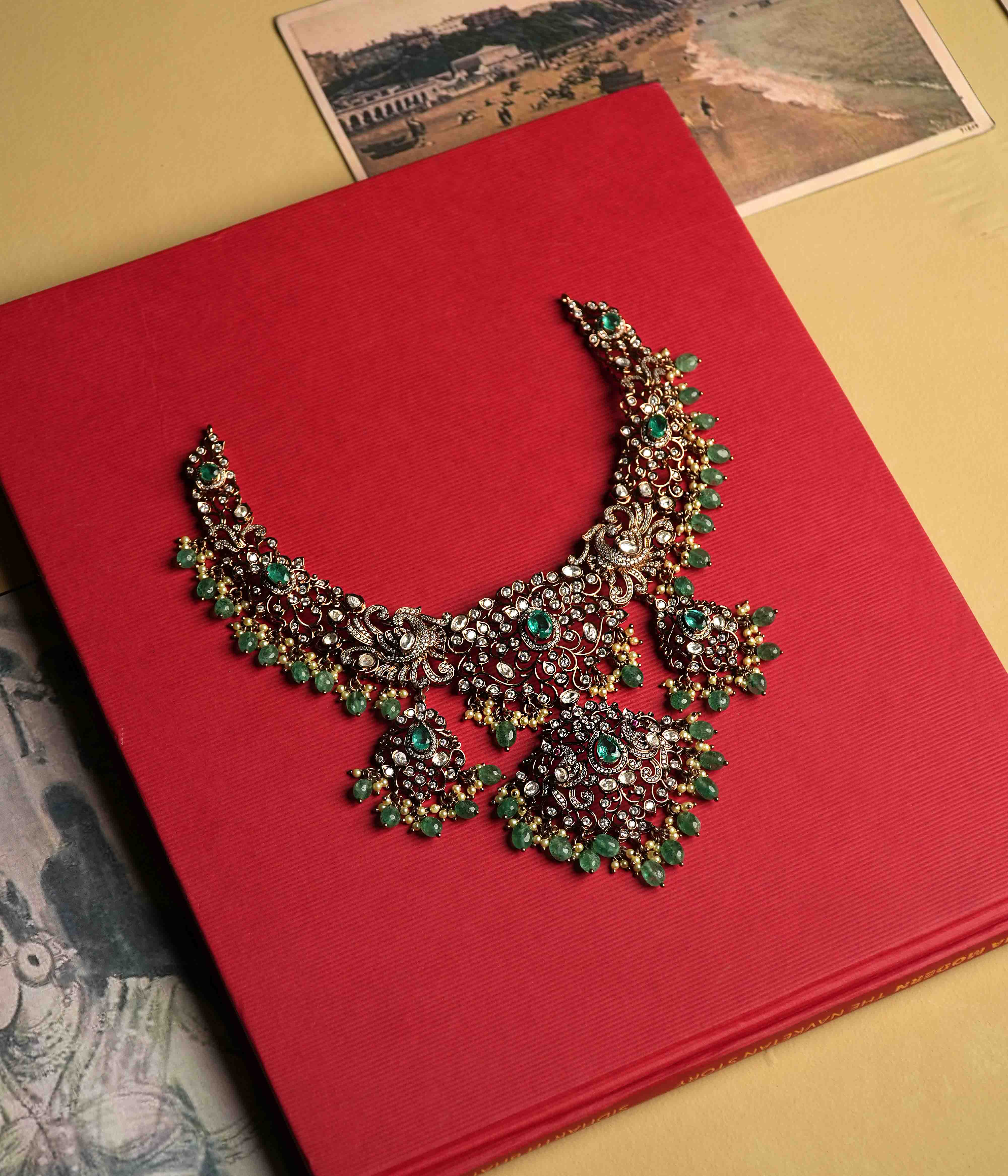 An elaborate moissanite necklace handcrafted from 92.5 sterling silver with 14ct dark antique gold plating, featuring CZ stones, a green gemstone, polki stones, and pearls, finished in a Victorian style, with cultured emerald and pearl dangles evoking vintage luxury.