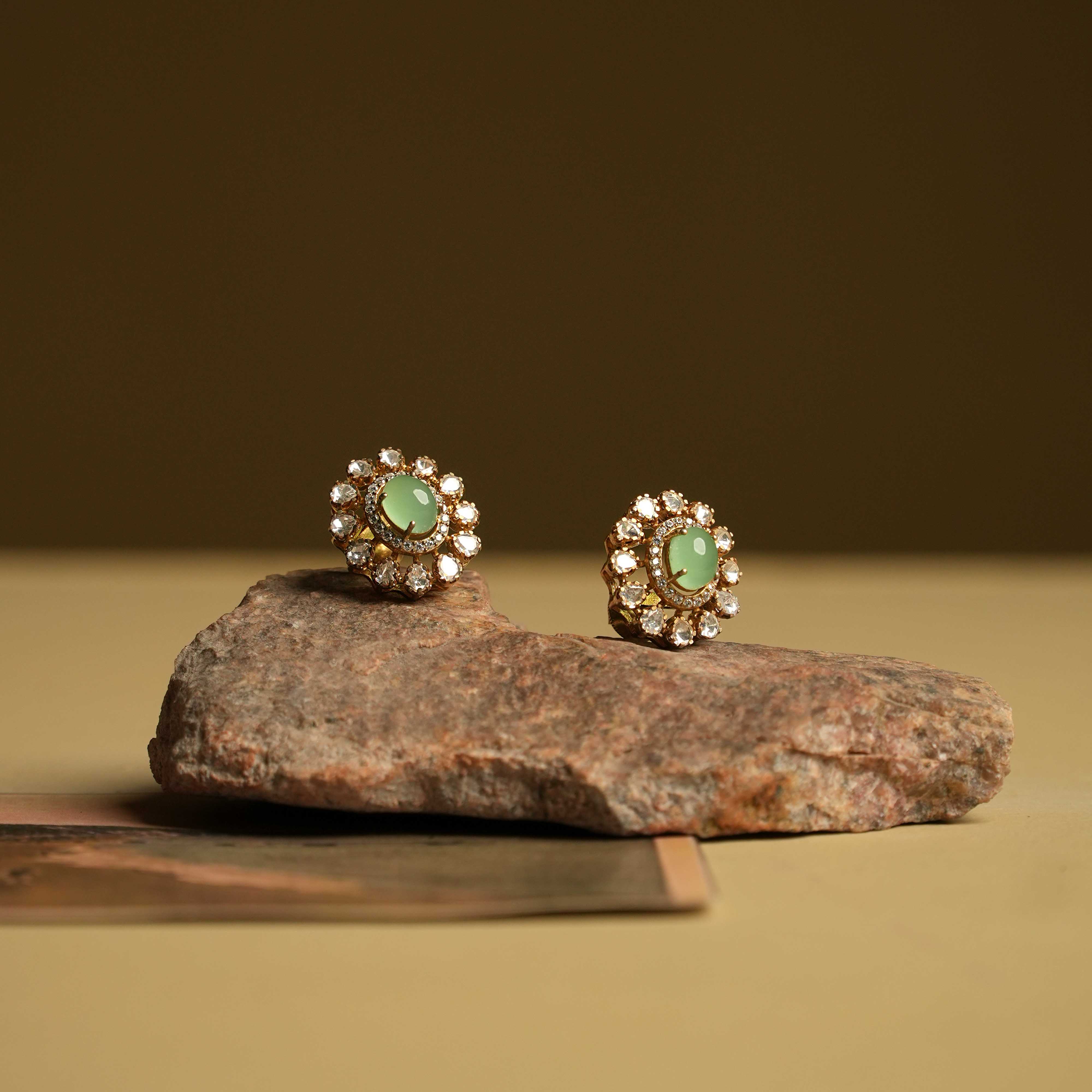 Minimalist 92.5 sterling silver ear stud featuring a bold green oval gemstone at the center, surrounded by moissanite polki stones and CZ accents. A perfect blend of subtle sophistication and vibrant elegance, ideal for those who appreciate refined simplicity