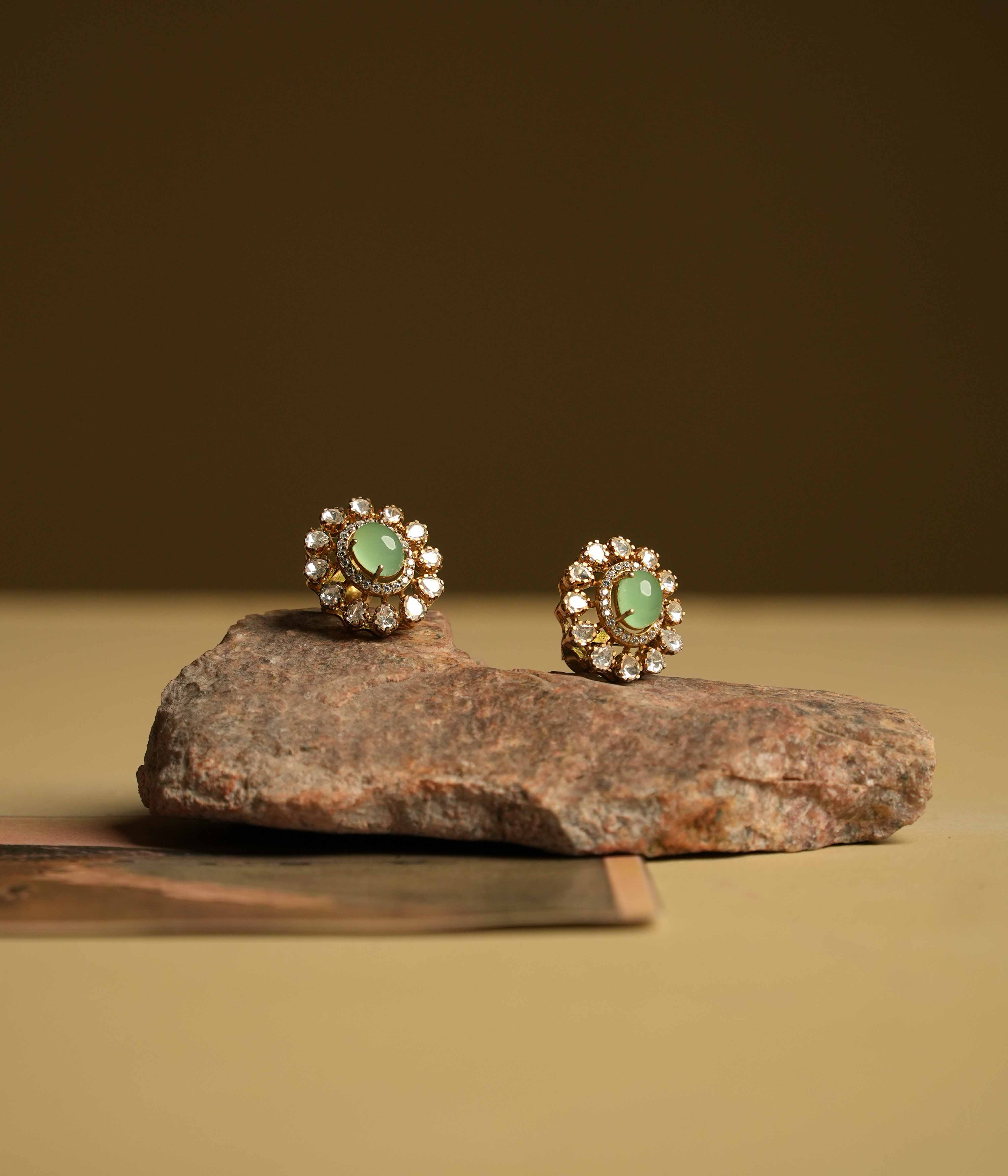 Minimalist 92.5 sterling silver ear stud featuring a bold green oval gemstone at the center, surrounded by moissanite polki stones and CZ accents. A perfect blend of subtle sophistication and vibrant elegance, ideal for those who appreciate refined simplicity