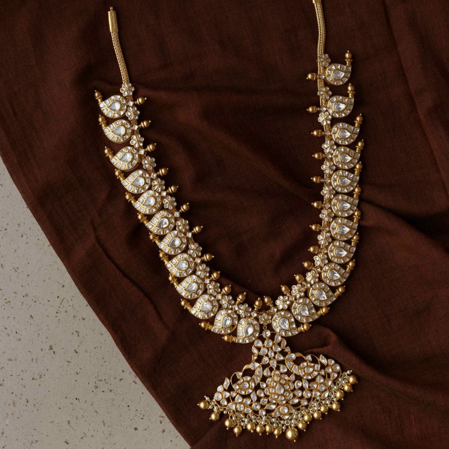 A necklace of enchantment, Woven with Polki Stones , it crowns its wearer in regal splendor.