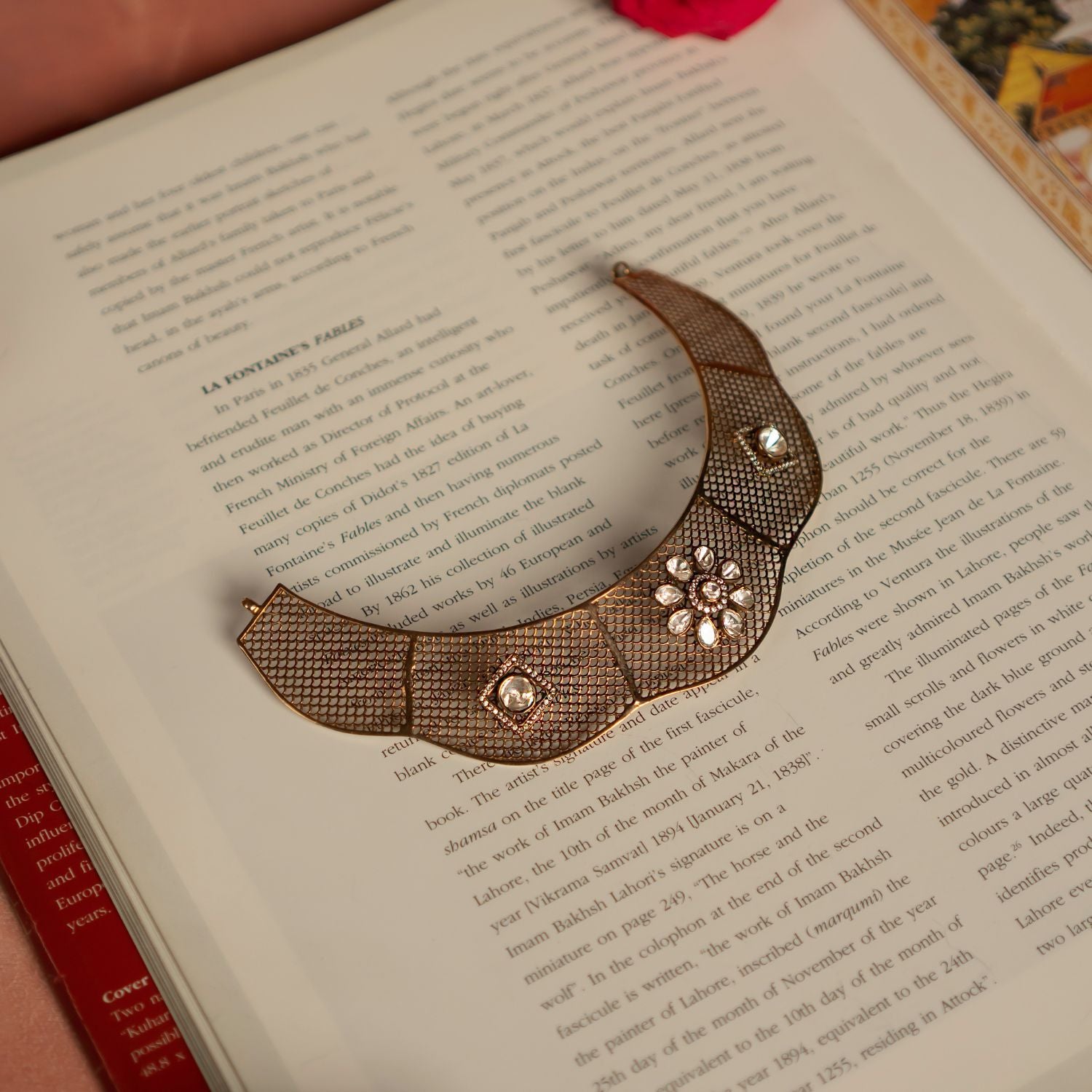 An exquisite gold-plated silver choker showcasing an intricate mesh design, adorned with dazzling CZ stones and Polki stones. The structured silhouette highlights a floral-shaped Polki motif, elegantly framed by fine CZ stone detailing, adding a regal touch. The seamless fusion of textures and embellishments exudes a luxurious, vintage charm, making this choker a timeless statement piece.