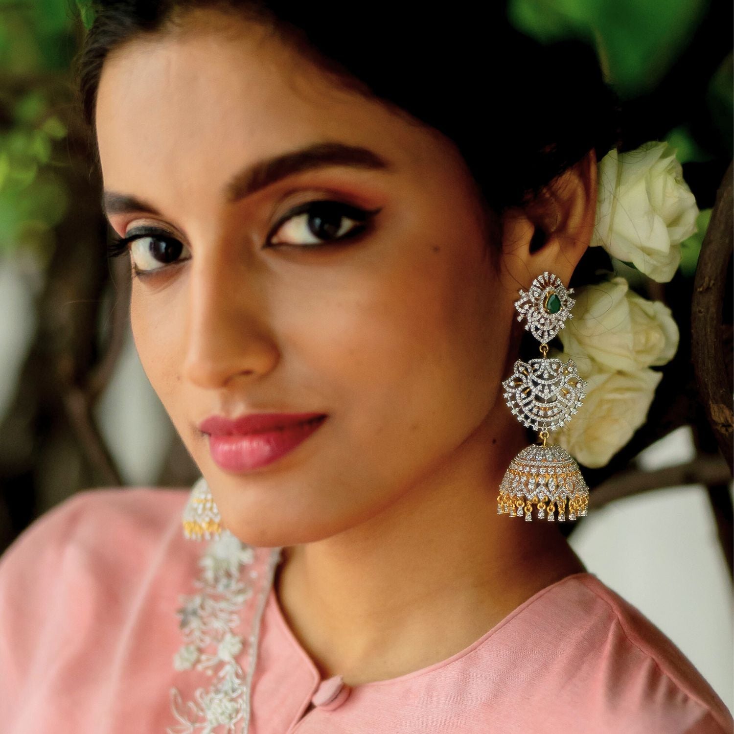 The Nakshatra Stone Jhumka features a mesmerizing green doublet stone and dazzling CZ accents, exuding timeless elegance with a radiant charm.