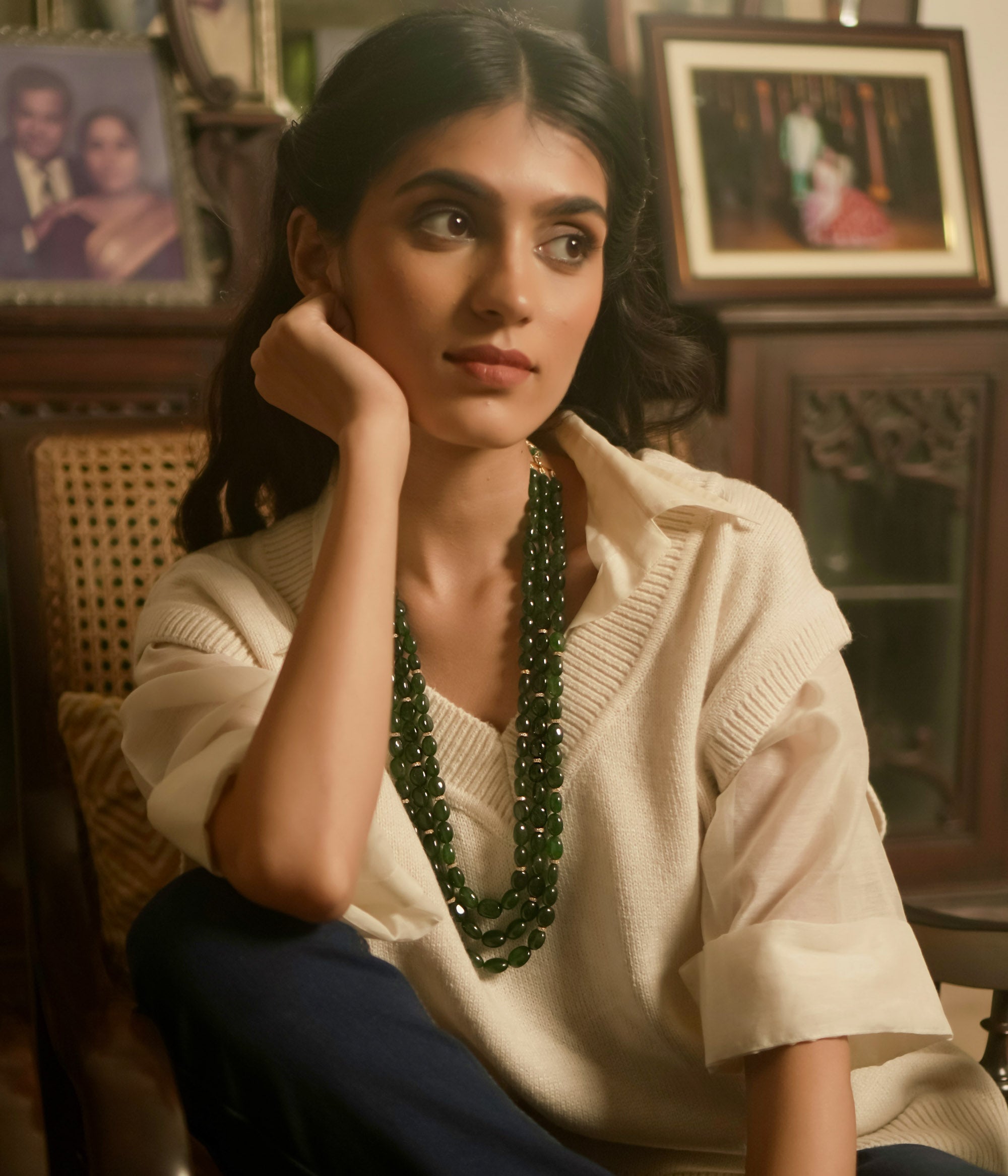 Resting in an elegant display, the triple-layered green strawberry necklace glows with a radiant allure, its rich hues catching the light with every delicate movement.