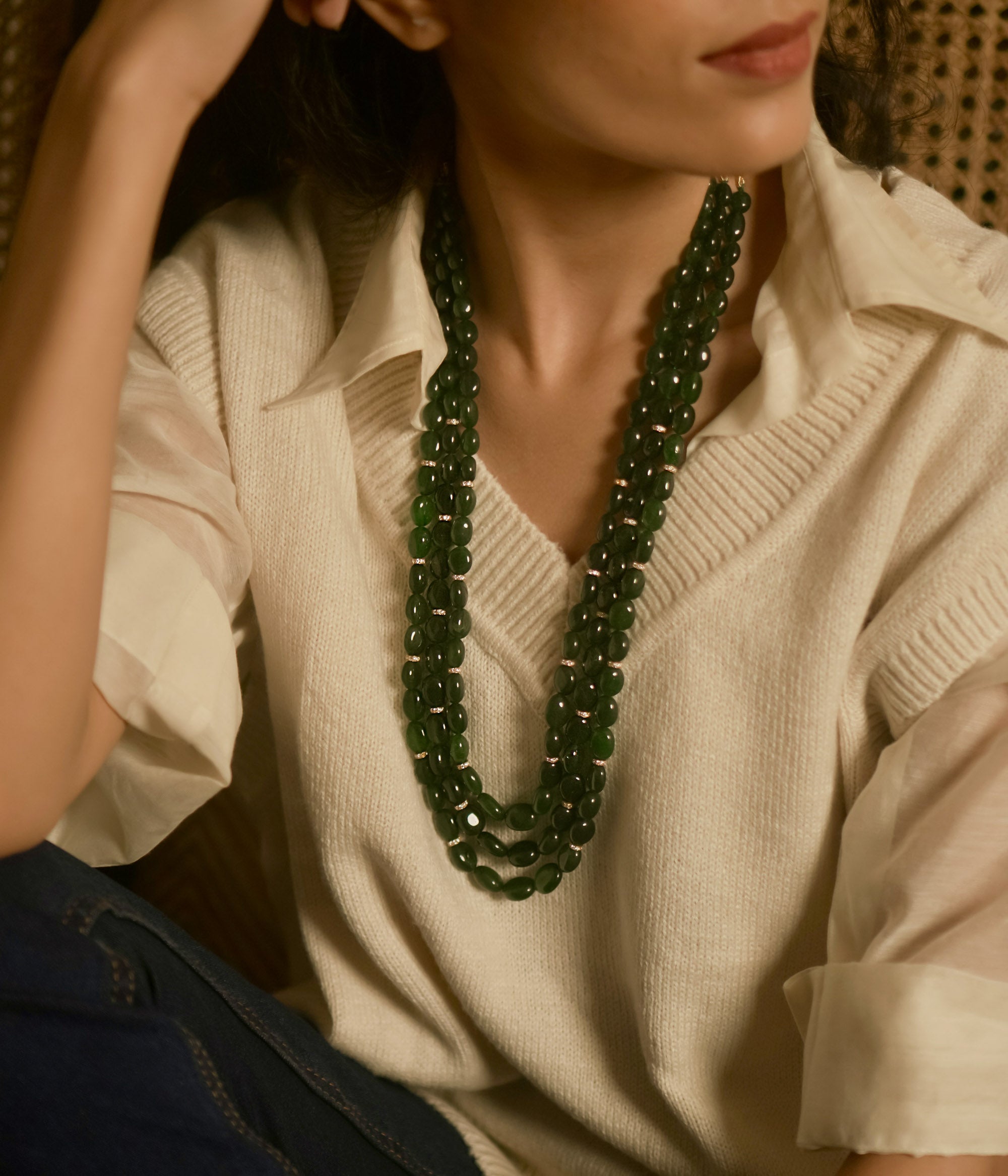 Resting in an elegant display, the triple-layered green strawberry necklace glows with a radiant allure, its rich hues catching the light with every delicate movement.