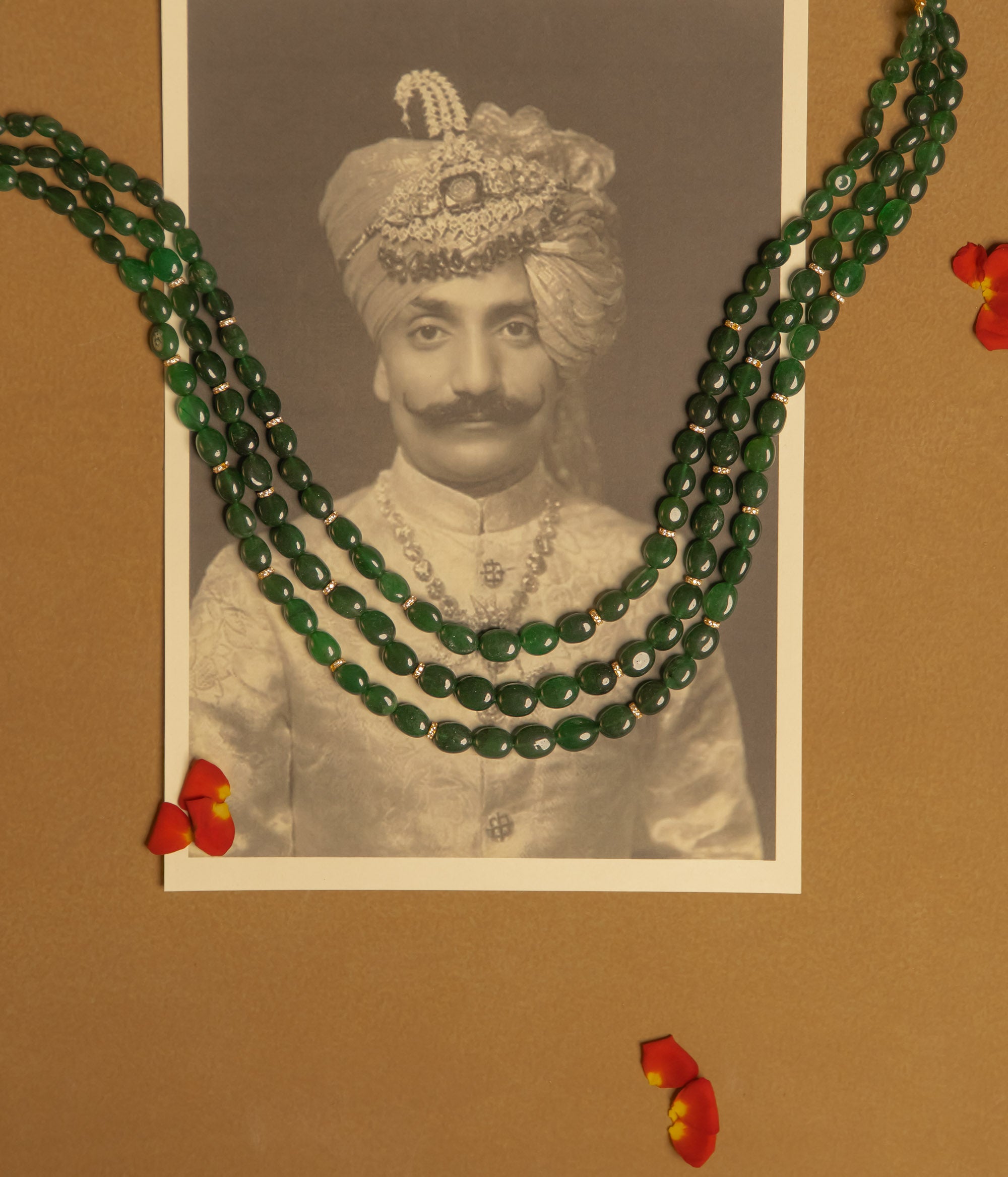 Resting in an elegant display, the triple-layered green strawberry necklace glows with a radiant allure, its rich hues catching the light with every delicate movement.