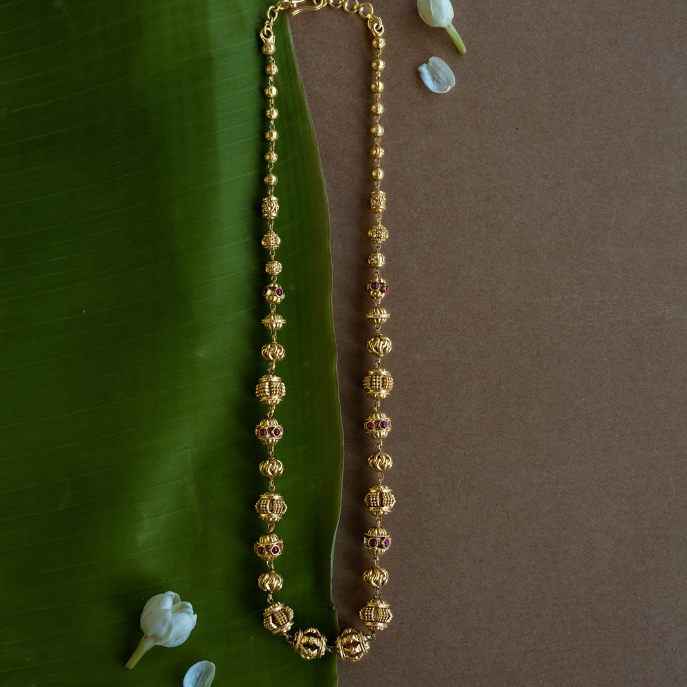 Golden beaded chain with ornate spherical motifs and red spinel accents from the Plain Collection.