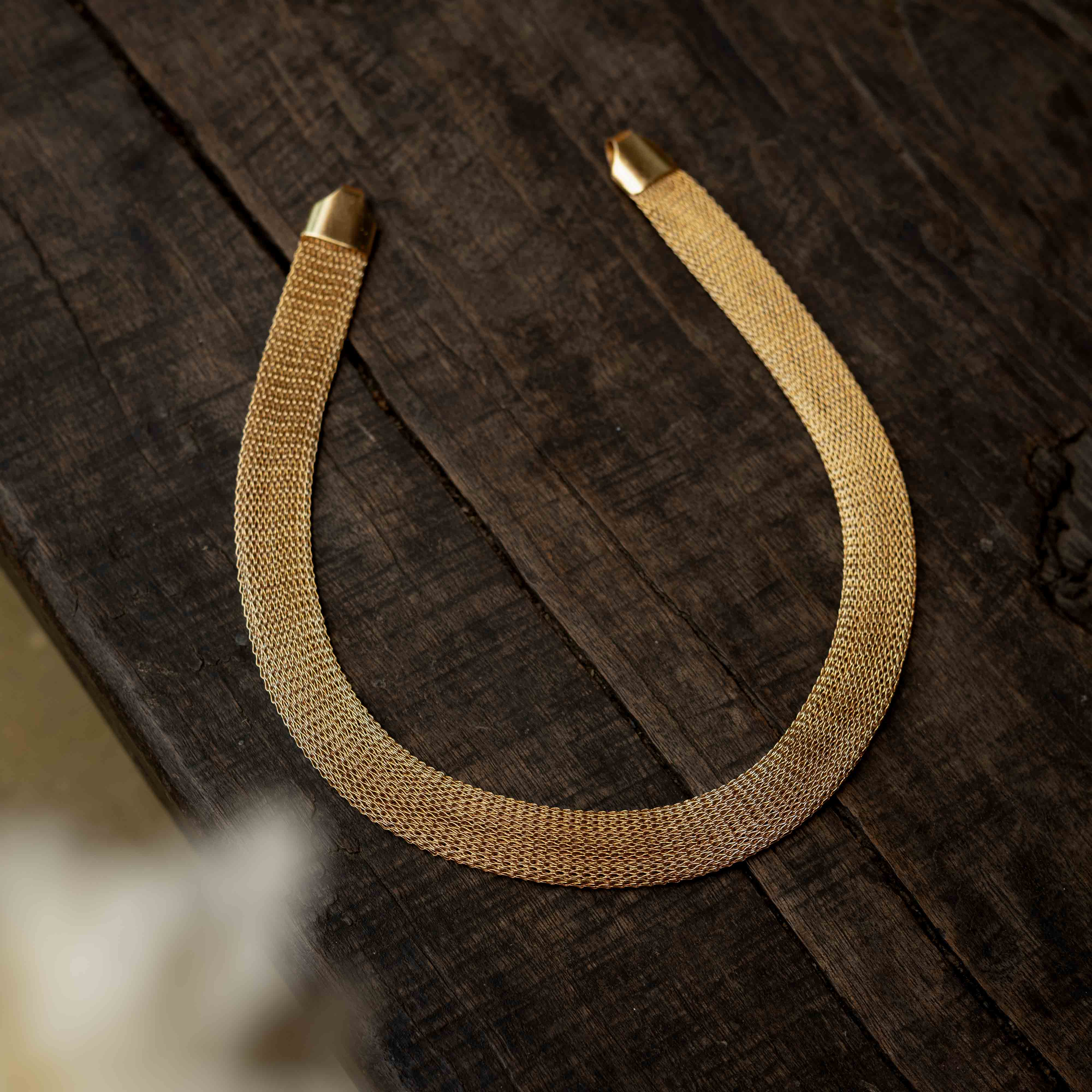 A multi-strand long chain made of small, gold-toned beads.