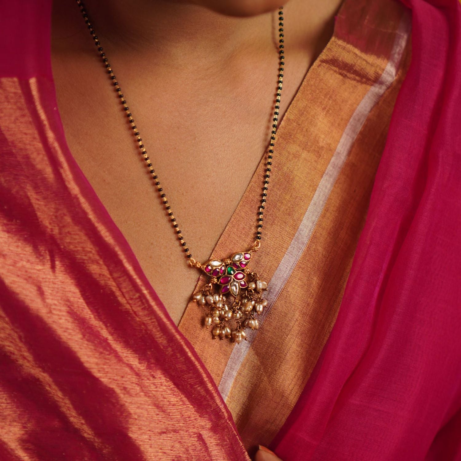 The Pansy Mangalsutra, crafted in gold-plated silver with radiant kundan stones and delicate pearl drops, seamlessly merges tradition with contemporary elegance. A timeless piece that celebrates heritage with a modern touch.