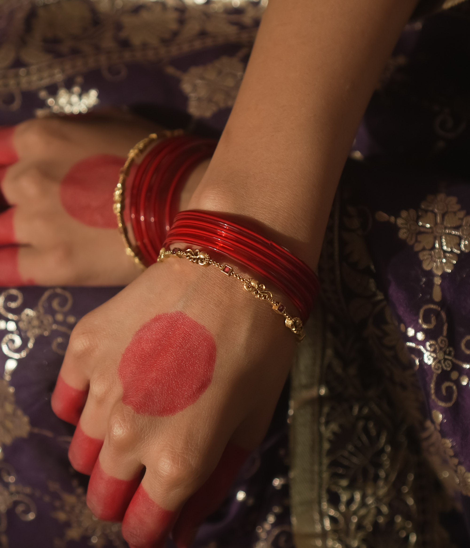 Antique gold-plated silver bangle with crimson threads and links.
