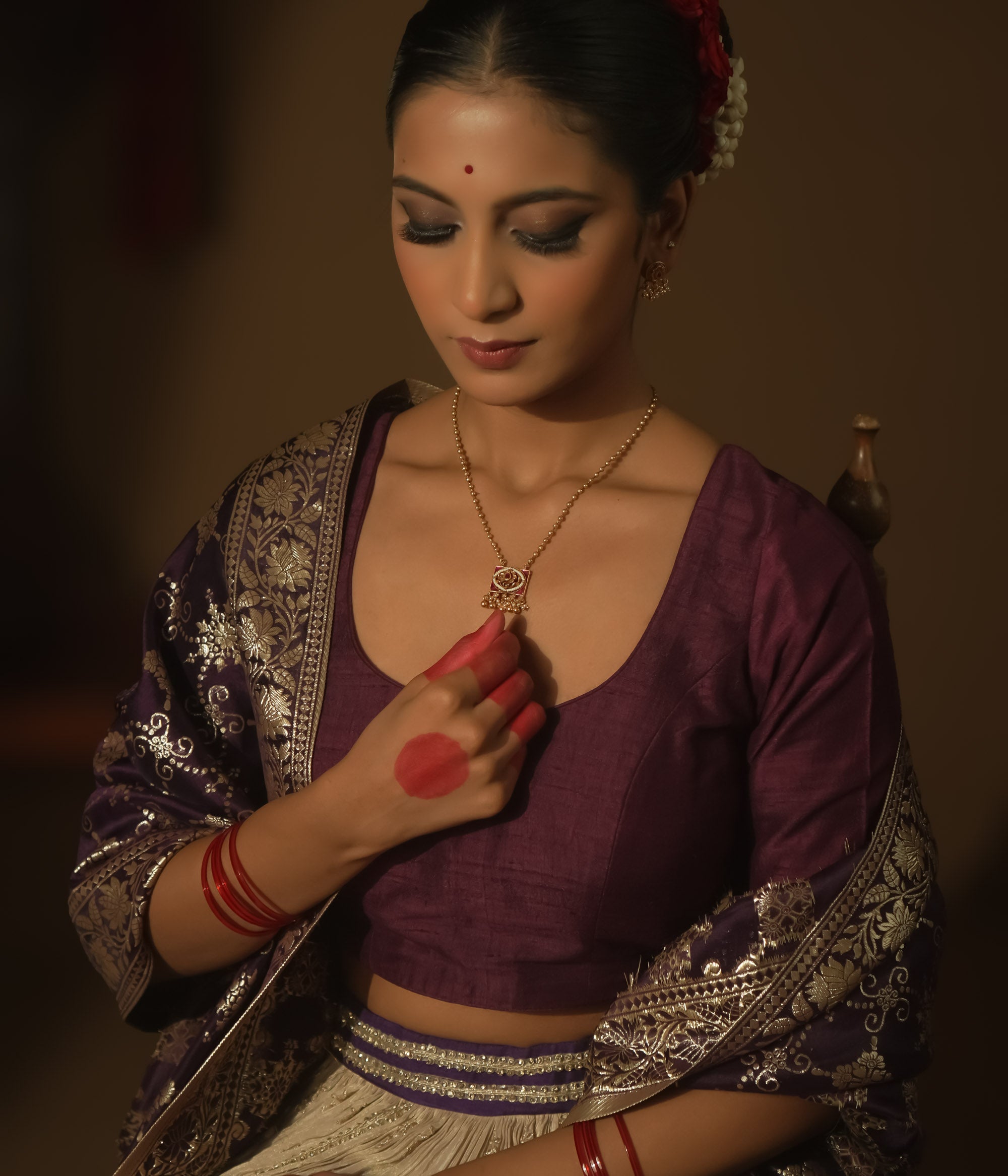 Necklace with gold beads and a square pendant with pink gemstones and gold filigree.