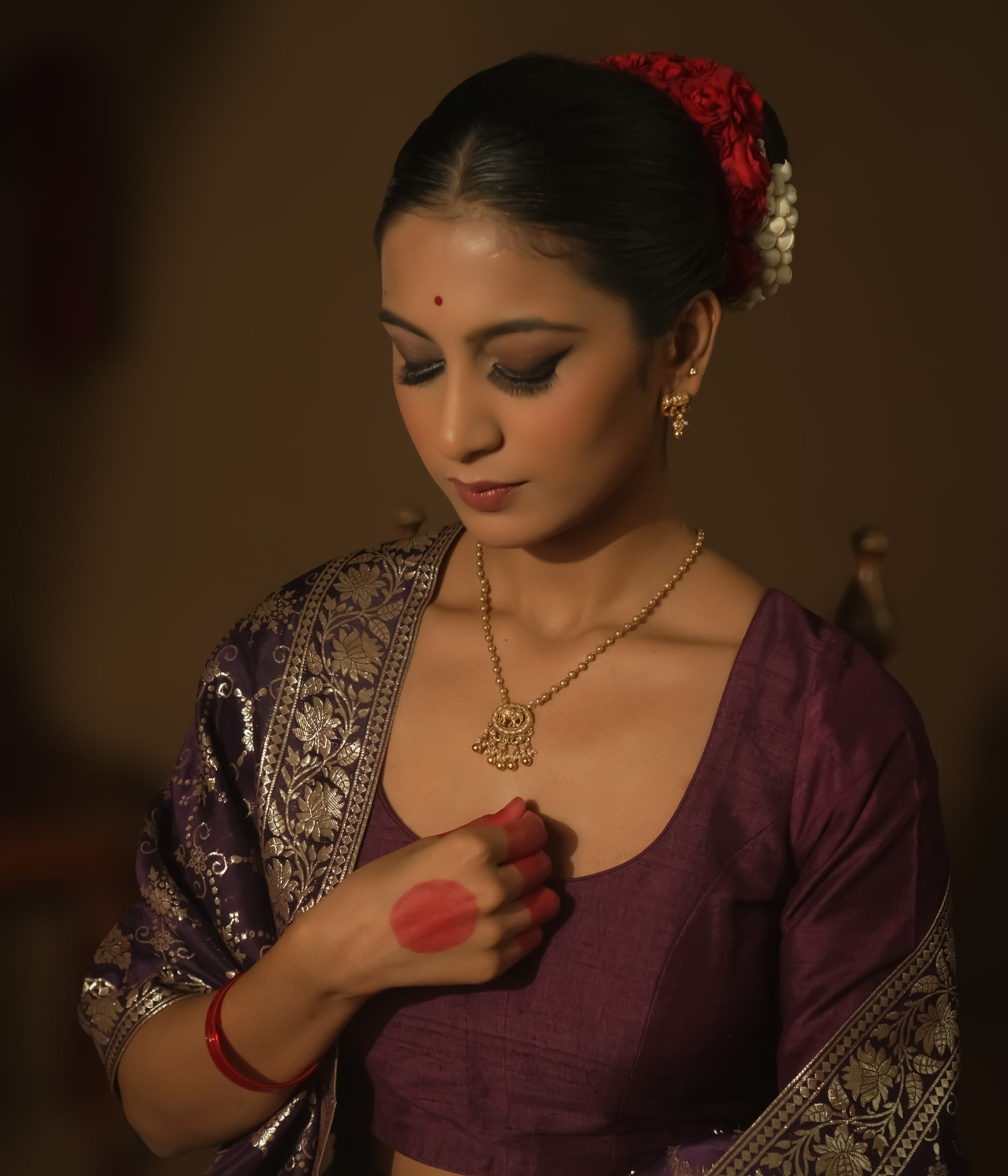 Gold necklace with a delicate chain and a pendant with an elephant silhouette.