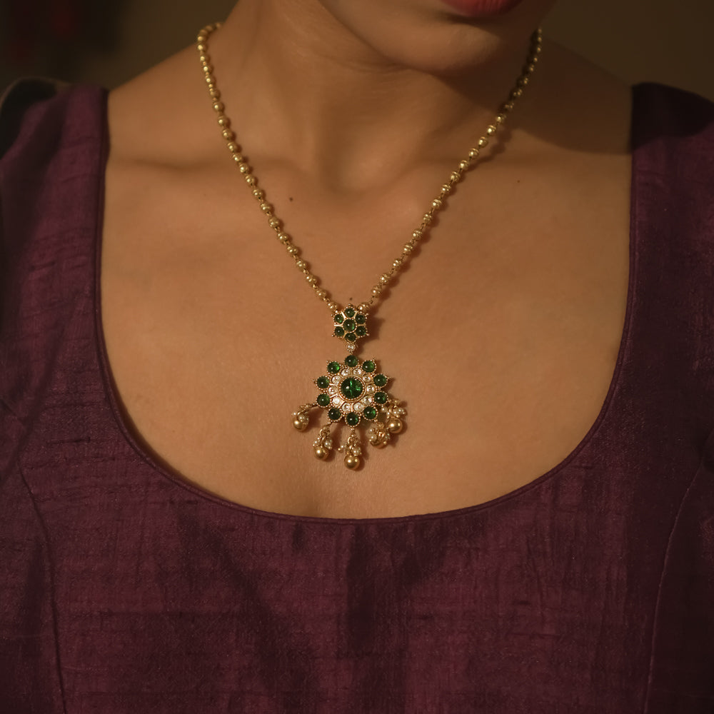 Gold-plated silver necklace with green gemstone beads and gold and pearl daisies.