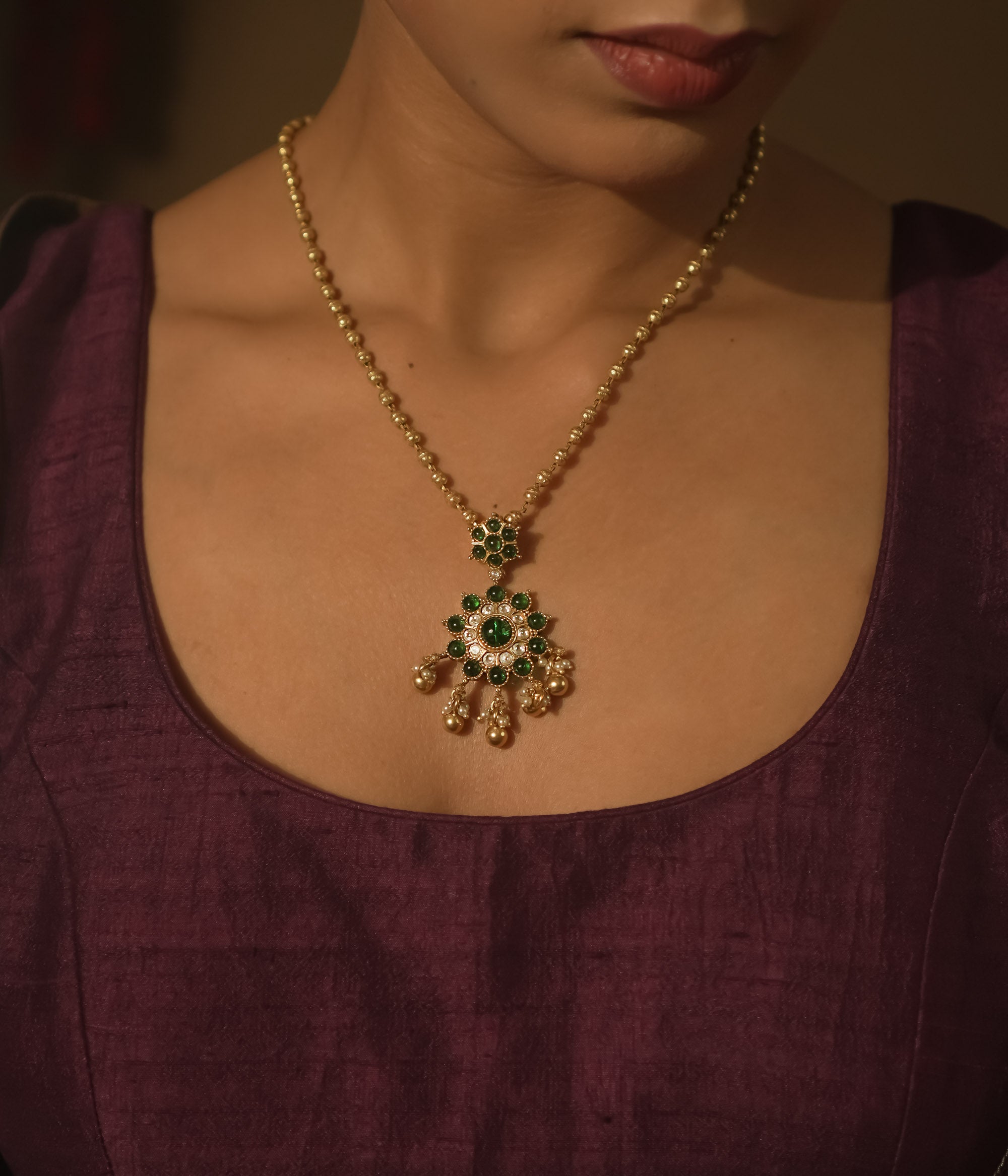 Gold-plated silver necklace with green gemstone beads and gold and pearl daisies.