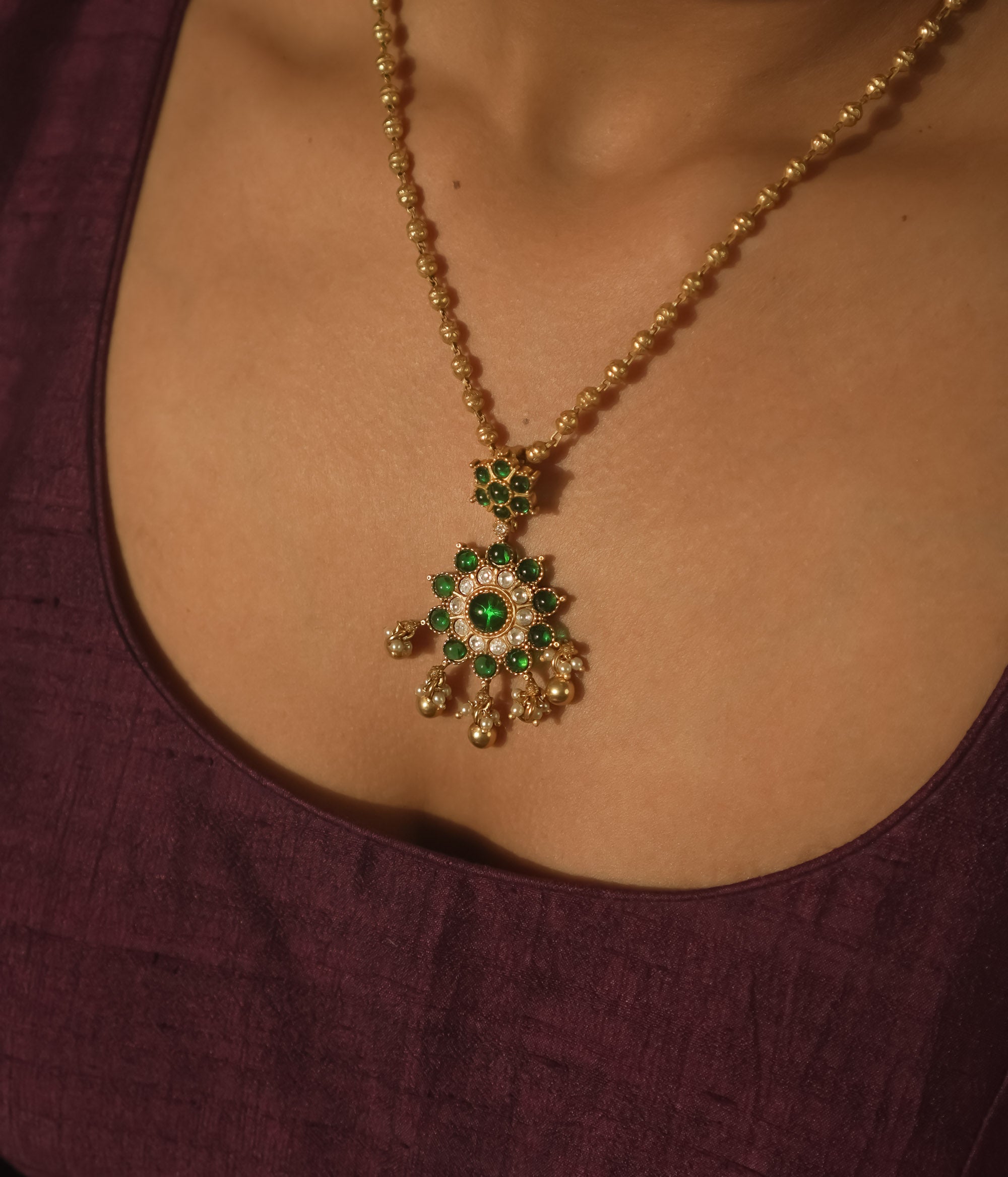 Gold-plated silver necklace with green gemstone beads and gold and pearl daisies.