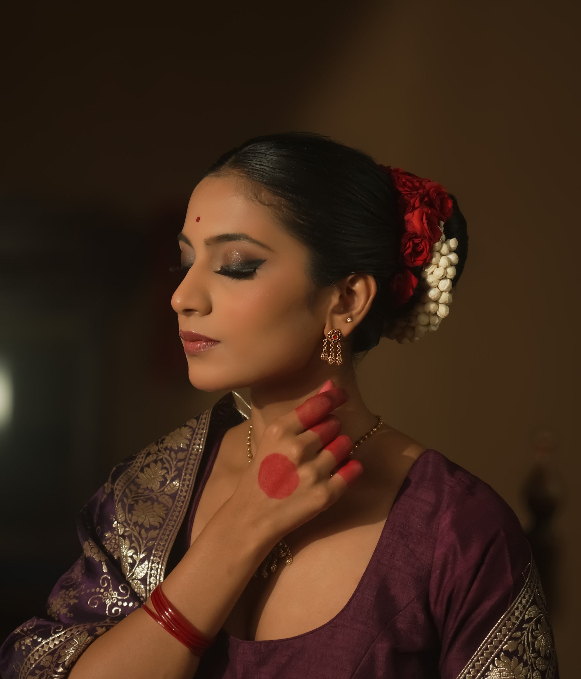 Earrings with chains of tiny coins and a central ruby red Kundan stone.