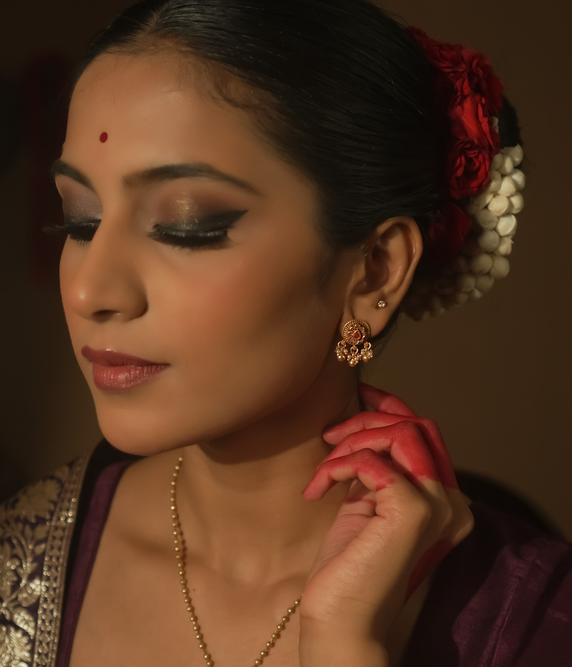 Gold-plated silver filigree earrings with a central crimson stone and tiny dangling beads.