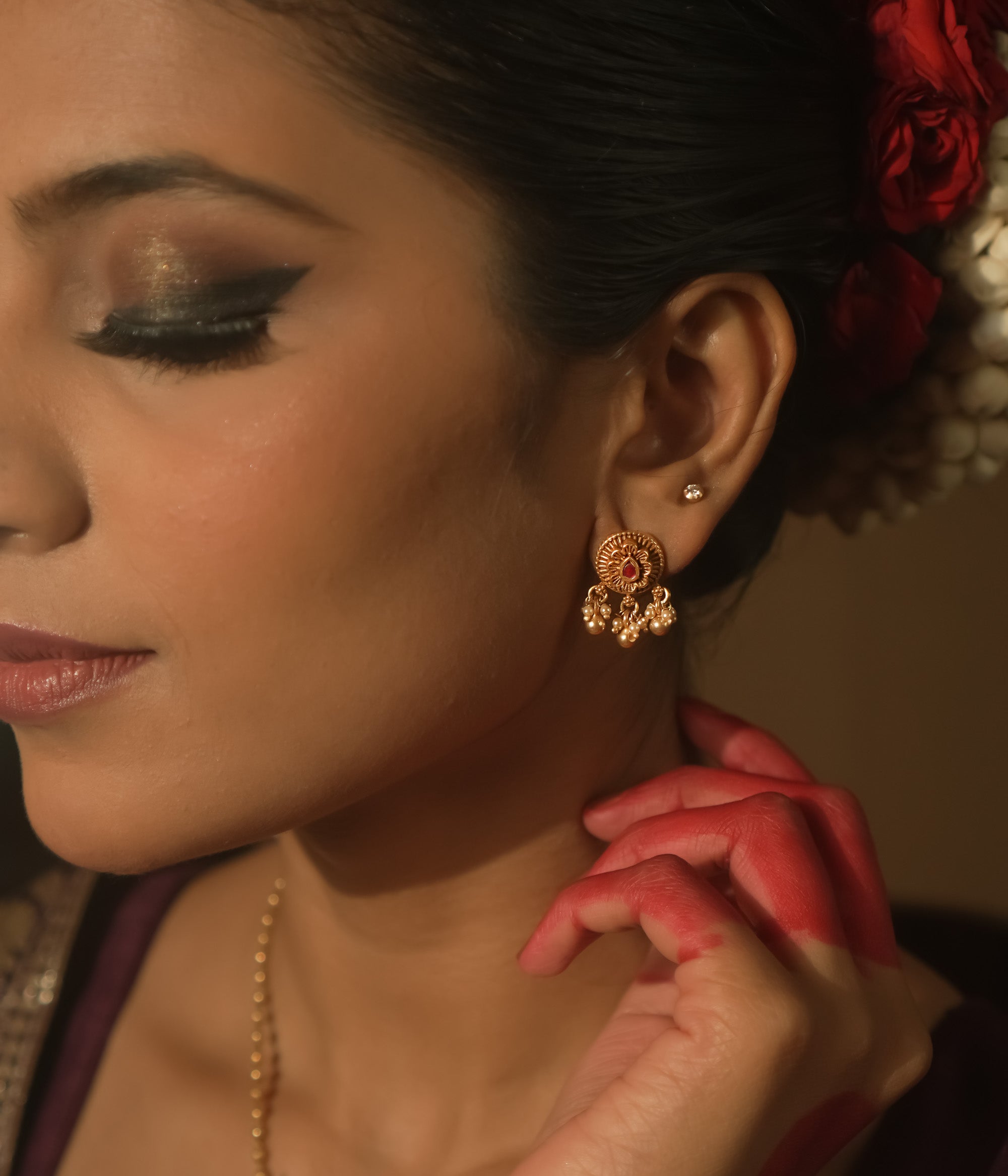 Gold-plated silver filigree earrings with a central crimson stone and tiny dangling beads.