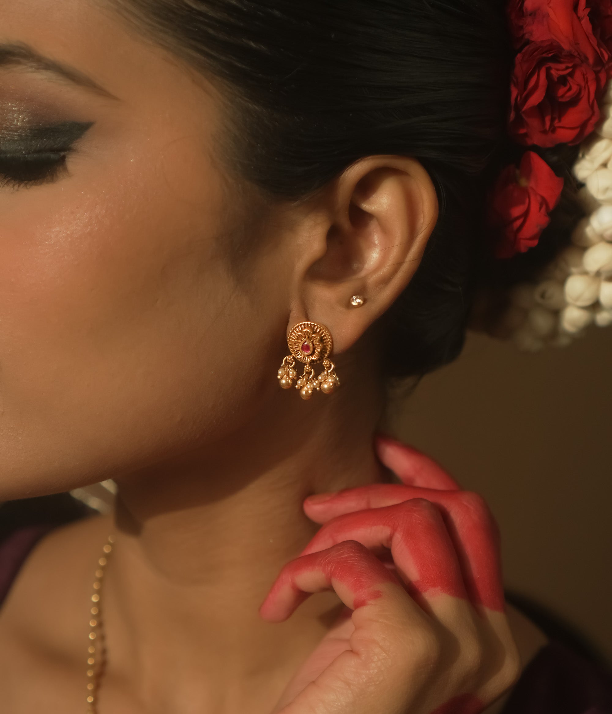 Gold-plated silver filigree earrings with a central crimson stone and tiny dangling beads.