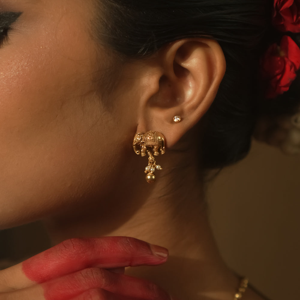 Gold-plated silver earrings with a tiny elephant motif.