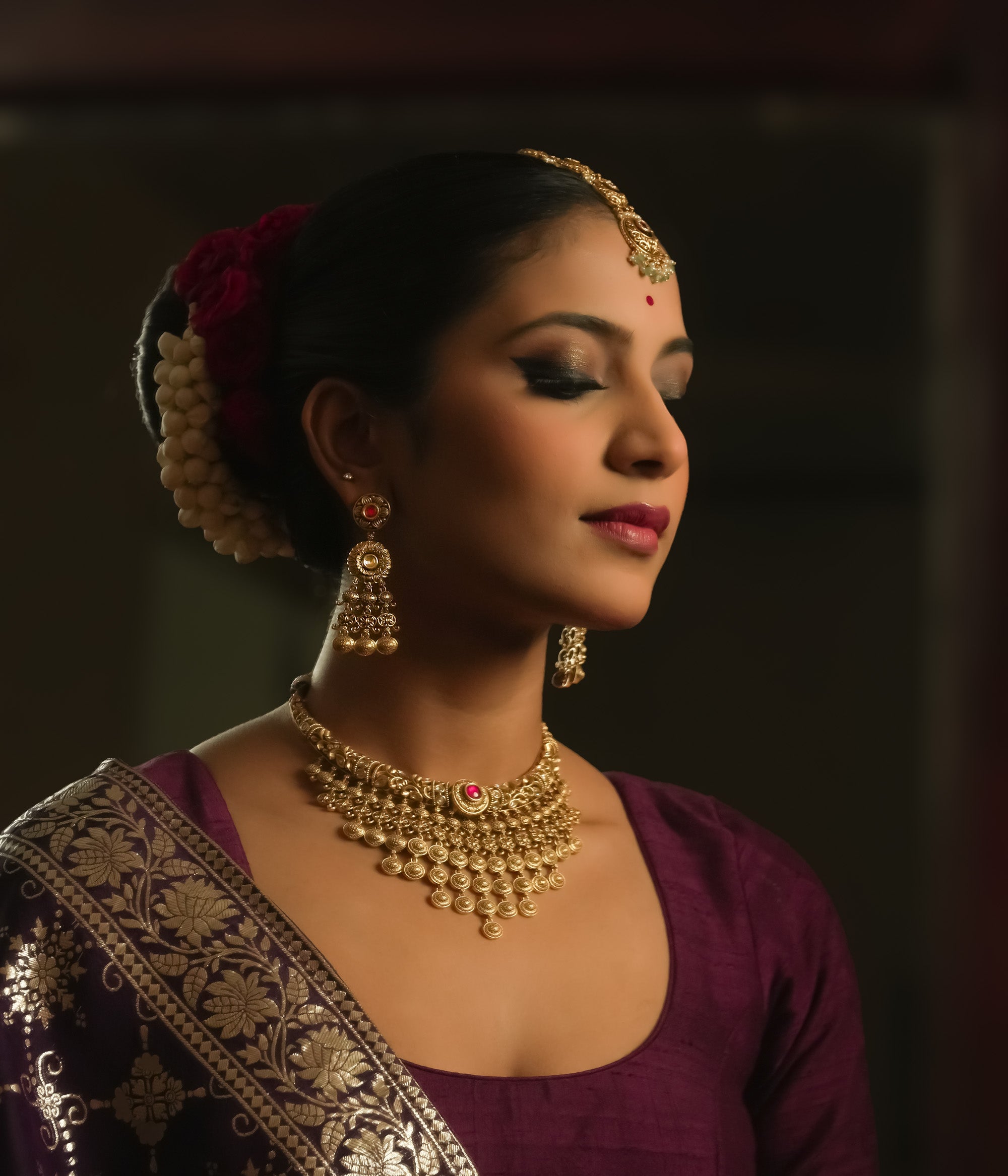 Gold-plated silver dangling earrings with a crimson gem, intricate loops, and tiny bells.