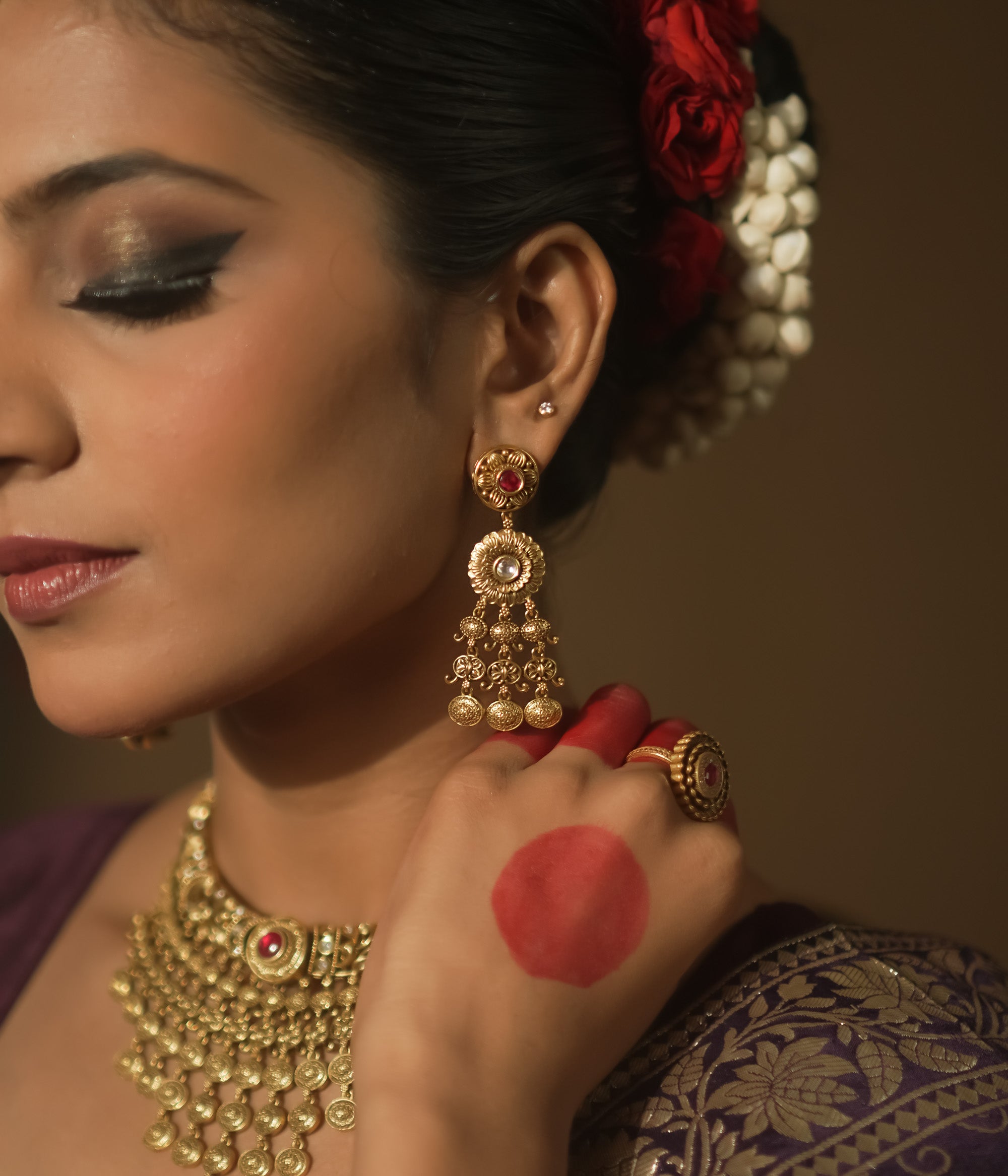 Gold-plated silver dangling earrings with a crimson gem, intricate loops, and tiny bells.