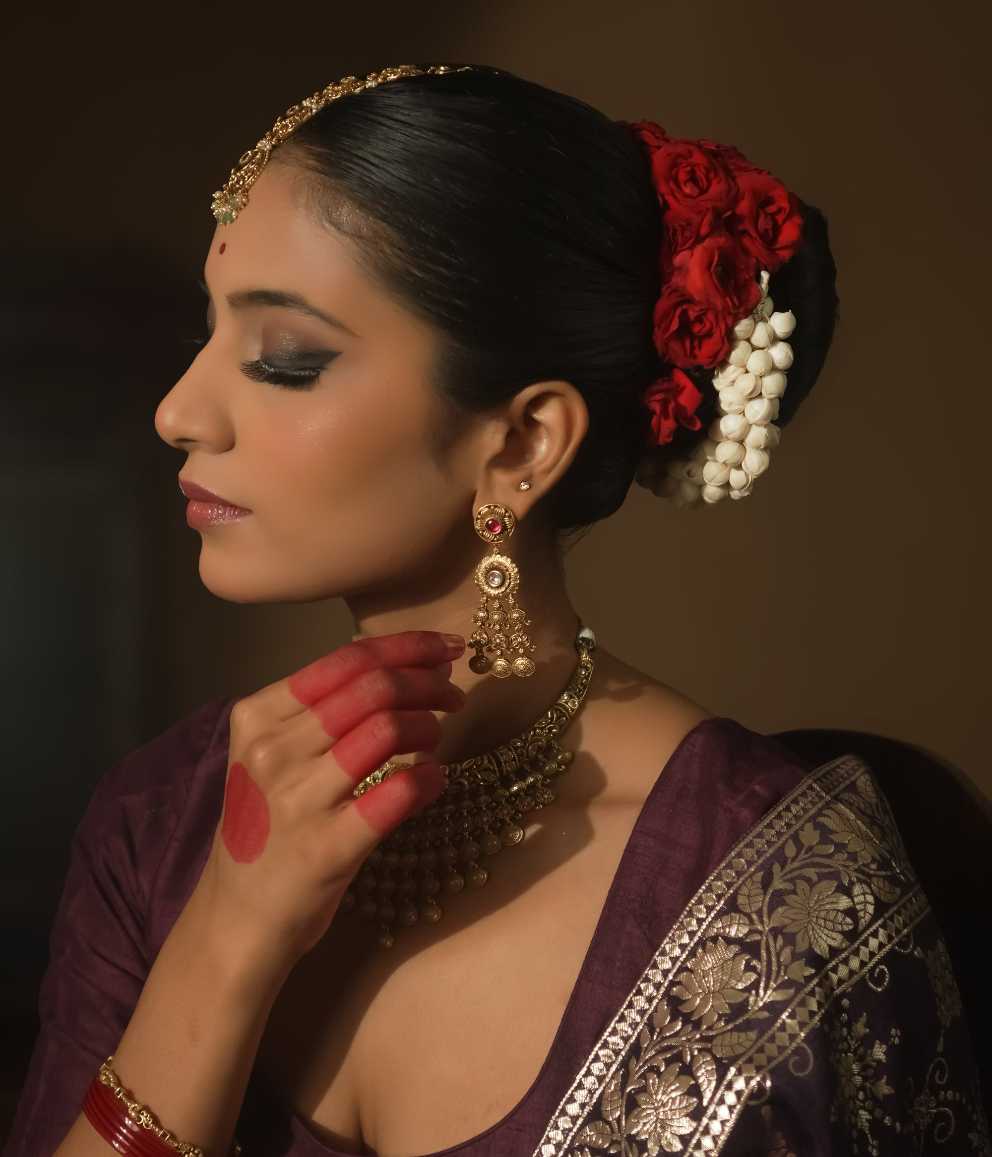 Gold-plated silver dangling earrings with a crimson gem, intricate loops, and tiny bells.