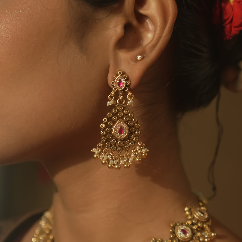 Gold-plated silver earrings with a teardrop shape, red gems, and cascading gold and pearl balls.